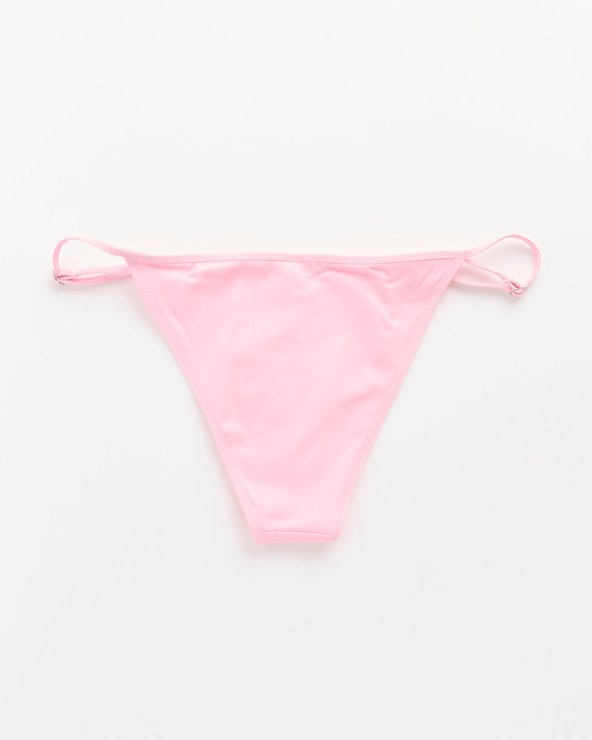 The Bella Bikini Bottom in Pink by Gimaguas is a low-rise swim bottom with adjustable side straps, shown against a plain white background.