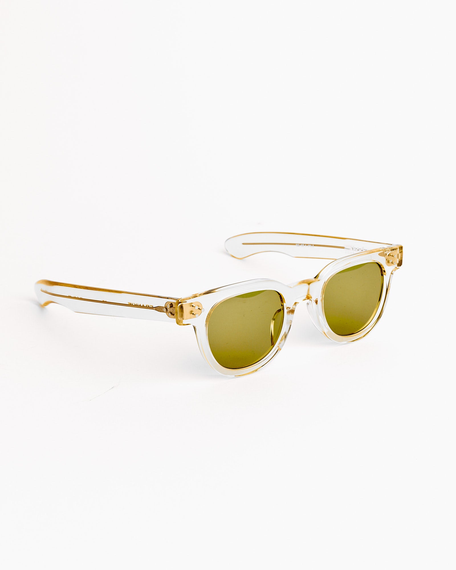 The Shady Character Frankie Sunglasses in Champagne/Mid Green feature transparent yellow frames and green-tinted lenses, displayed at an angle on a white background. Questions about size? Chat with us online for personalized help.
