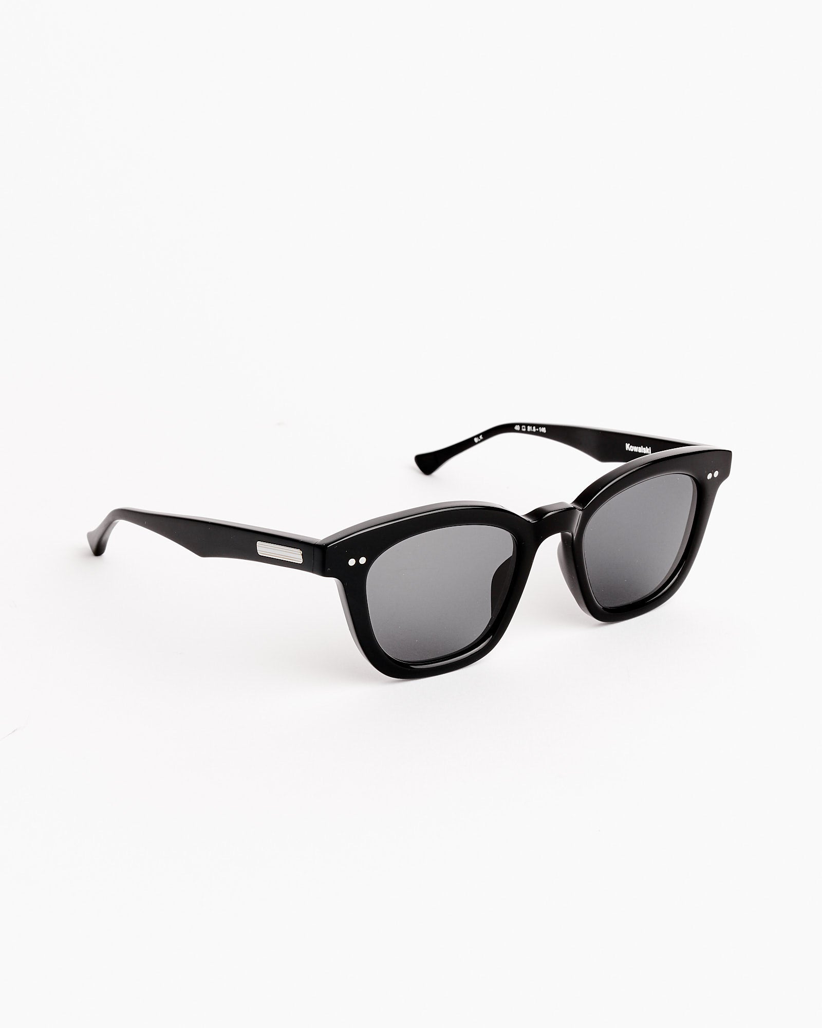 The Native Sons Kowalski 2 Sunglasses in Black/White Gold/GR-9 Dark Grey showcase rectangular frames with diamond-tooled accents and dark lenses, displayed against a white background.