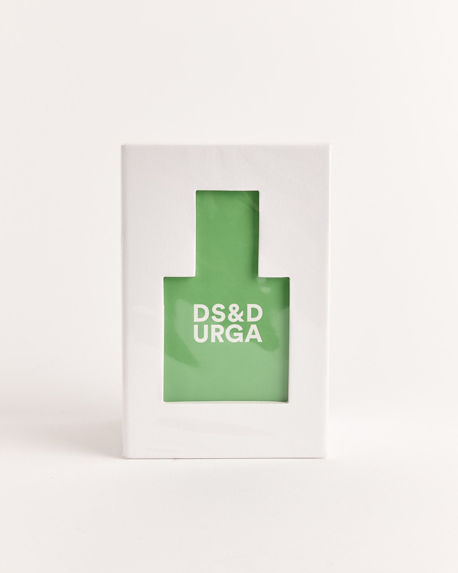 A green Eau de Parfum in Crush Balls bottle by D.S. & Durga, with white text, is shown inside a white box featuring a bottle-shaped window, set against a plain white background.