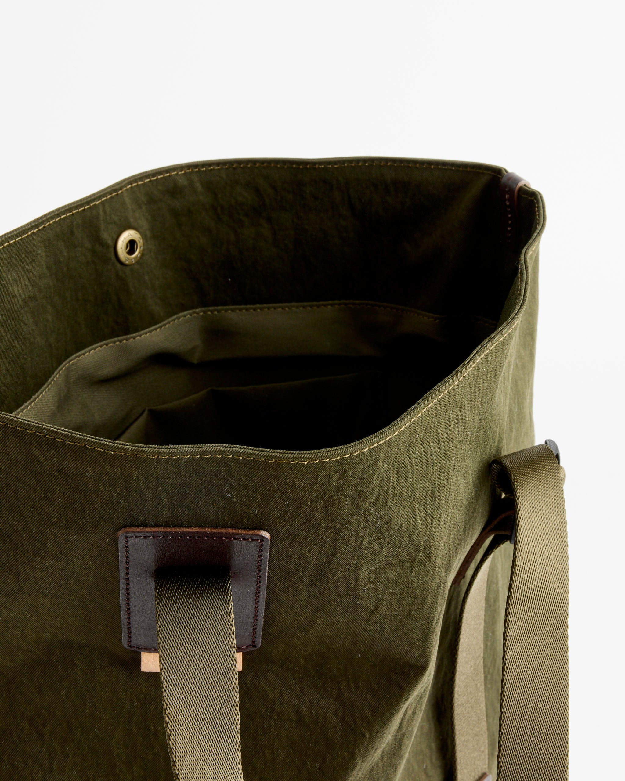 The Two Way Tote in Khaki Green by Hender Scheme features beige straps, leather trim, and visible inner pockets. For sizing or fit info, chat with us online. Shown on a plain white background.