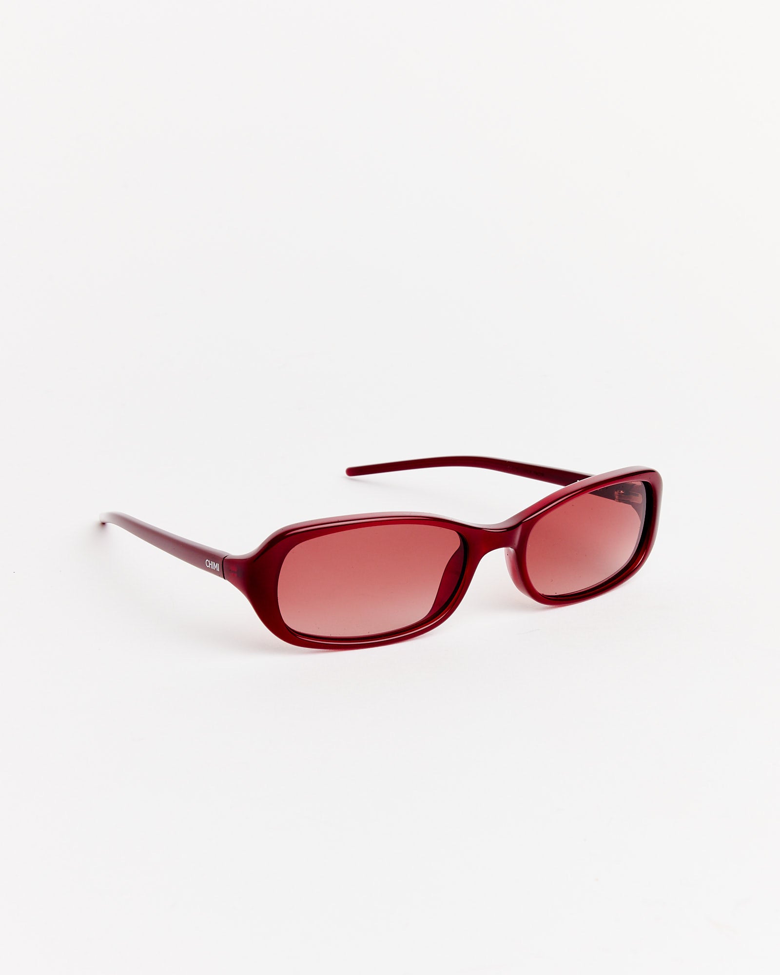 Chimi Code Sunglasses in Dark Red feature thick rectangular frames and matching red-tinted lenses, shown on a white background. Use our online chat for personalized sizing and fit advice.