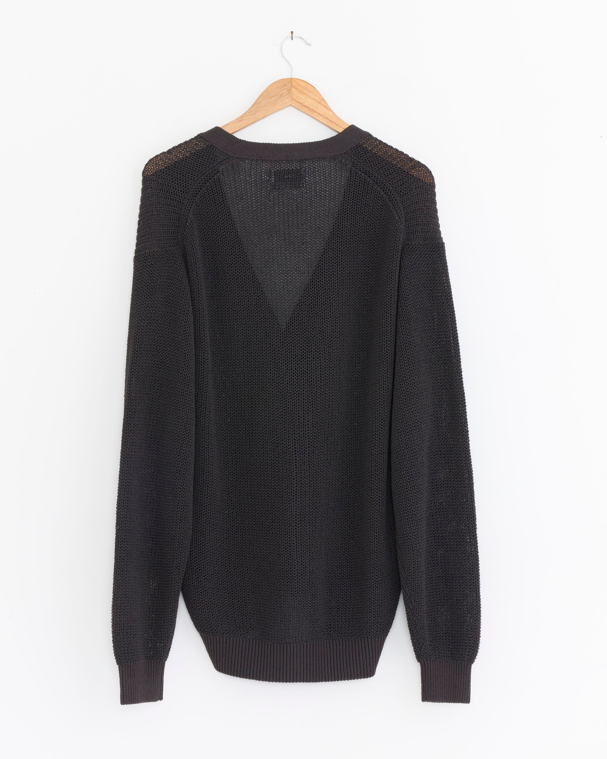 The Graphpaper Coiled Wool Nylon Cardigan in Charcoal, made in Japan, features ribbed cuffs and hem and a lightweight knit with a V-shaped back stitch. Displayed on a wooden hanger against a white background.