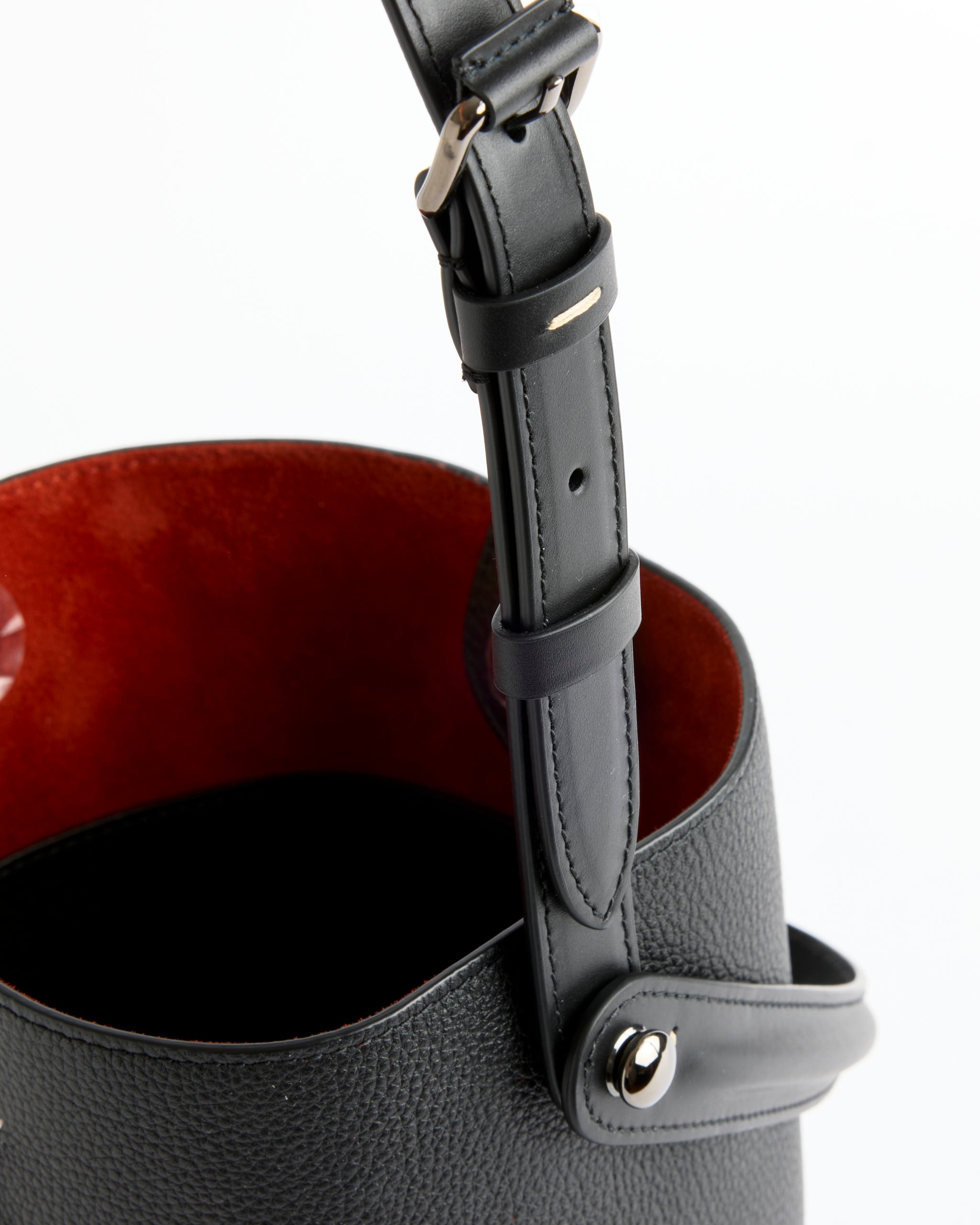 Close-up of the Maison Margiela Dress-Age Hobo Bag, featuring pebbled calfskin, equestrian-inspired details, adjustable strap with metal buckle, deep red lining, and a metal snap button on the side.