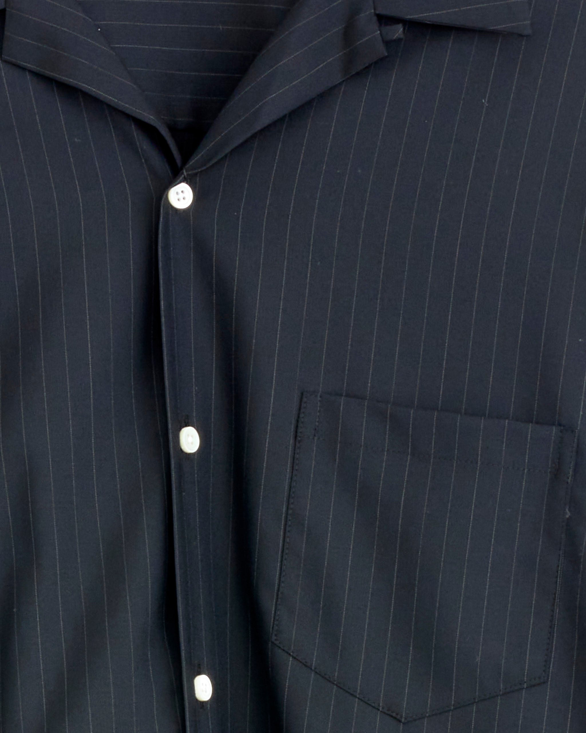 Close-up of the Sillage Re-Engineered Tropical Wool Overshirt in Stripe, featuring dark pinstripes, white buttons, lightweight breathable fabric, and a left chest pocket.