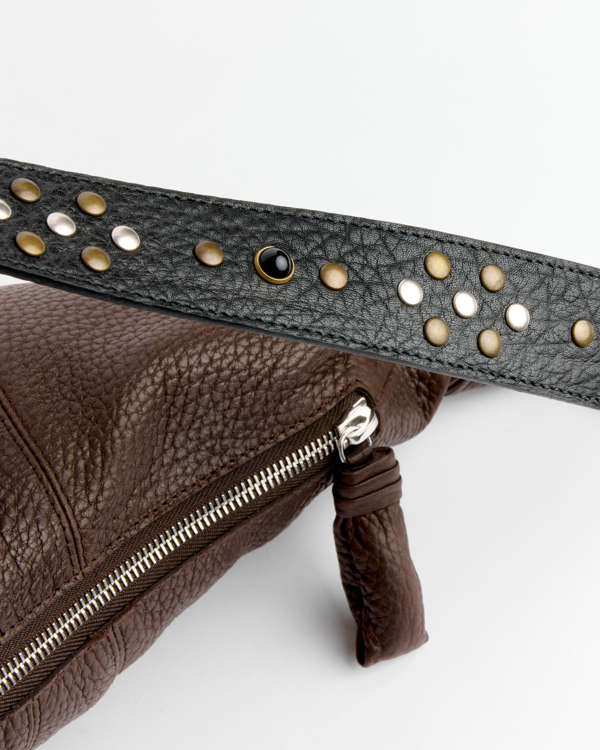 A close-up of the Lemaire Western Studs Medium Croissant Bag in Dark Chocolate cow leather, featuring a visible silver zipper and a black strap adorned with colorful western studs.