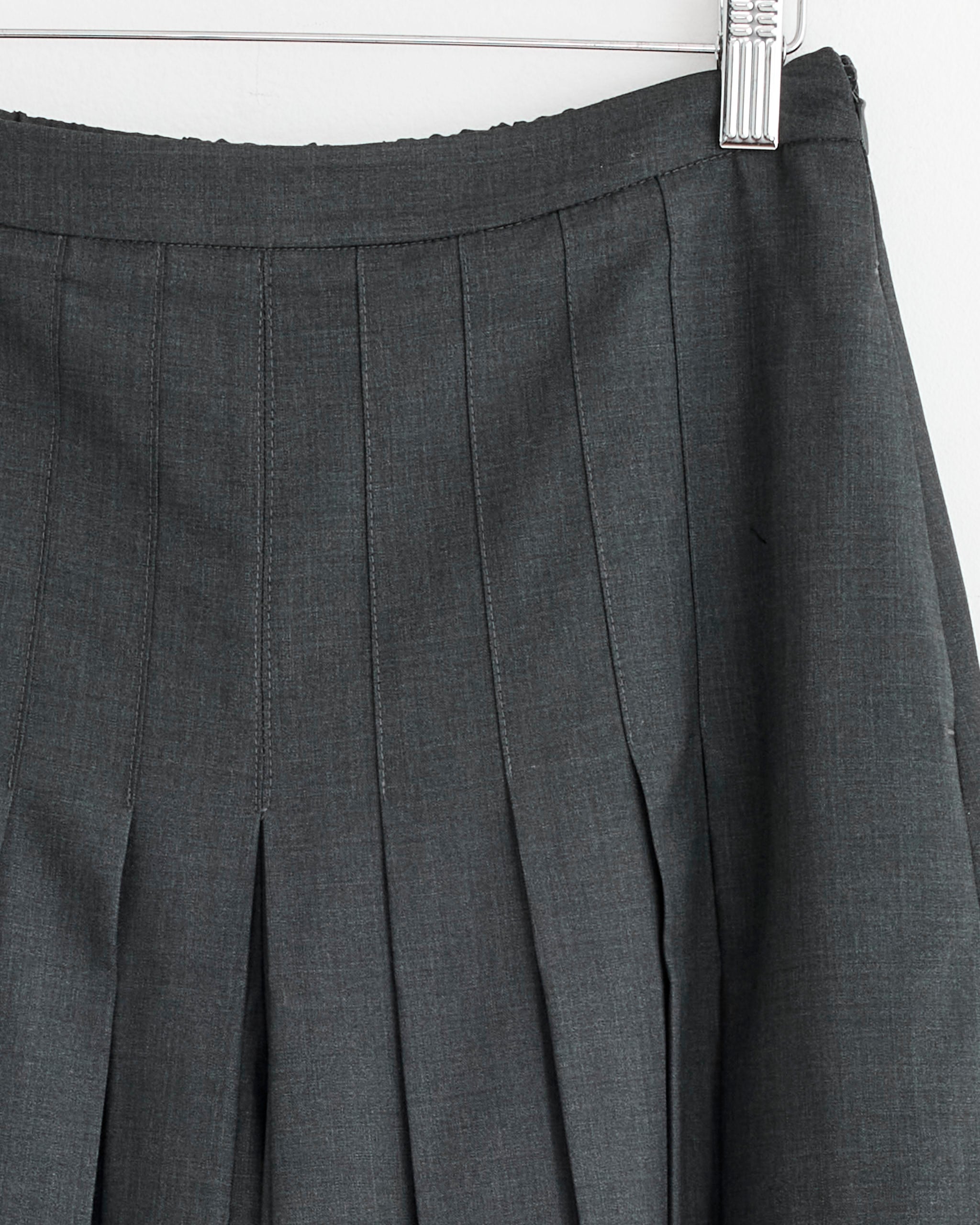 Close-up of the Amomento Pleated Wool Culotte in Charcoal, featuring pleats and an elastic waistband, displayed on a hanger against a white background.