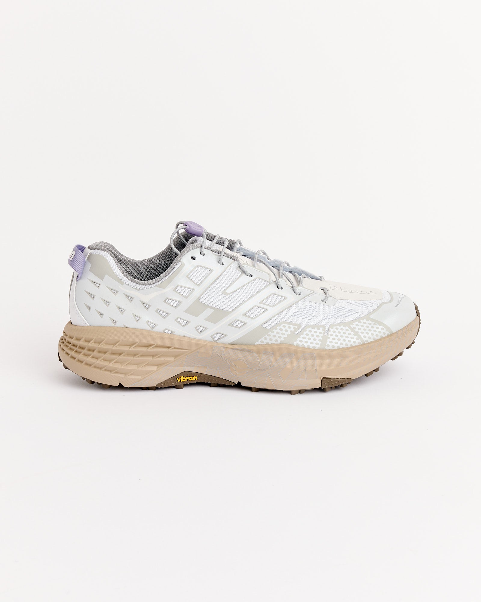 The Hoka SPEEDGOAT 2 UNNA in Sea Ice/Cosmic Grey features a light gray geometric design, thick beige sole, and purple heel accent—shown on a plain white background. Online chat is available for fit and sizing questions.