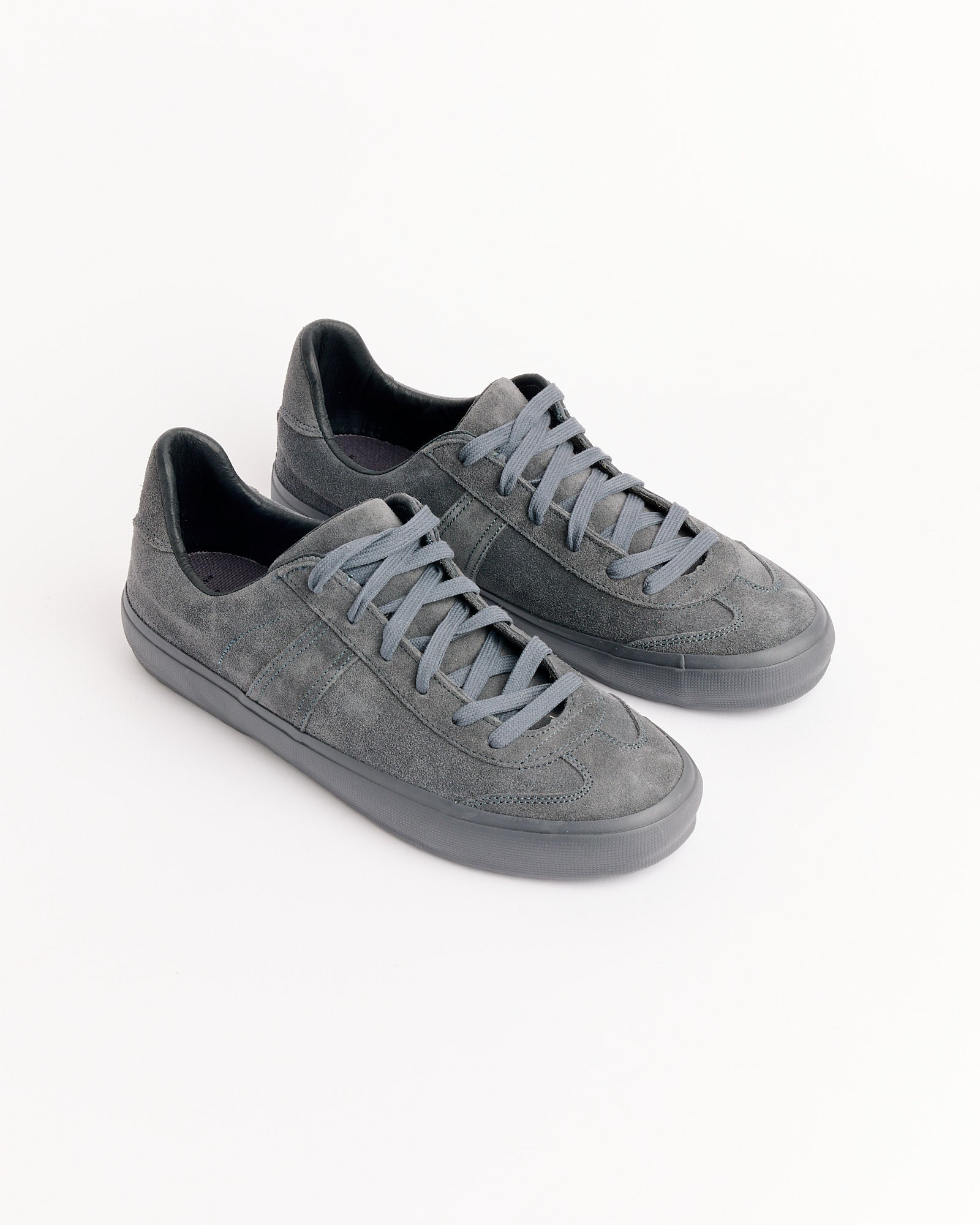 The Still By Hand x Reproduction Of Found Sneakers in Charcoal by Still By Hand feature gray suede, matching laces, and rubber soles, displayed on a plain white background.