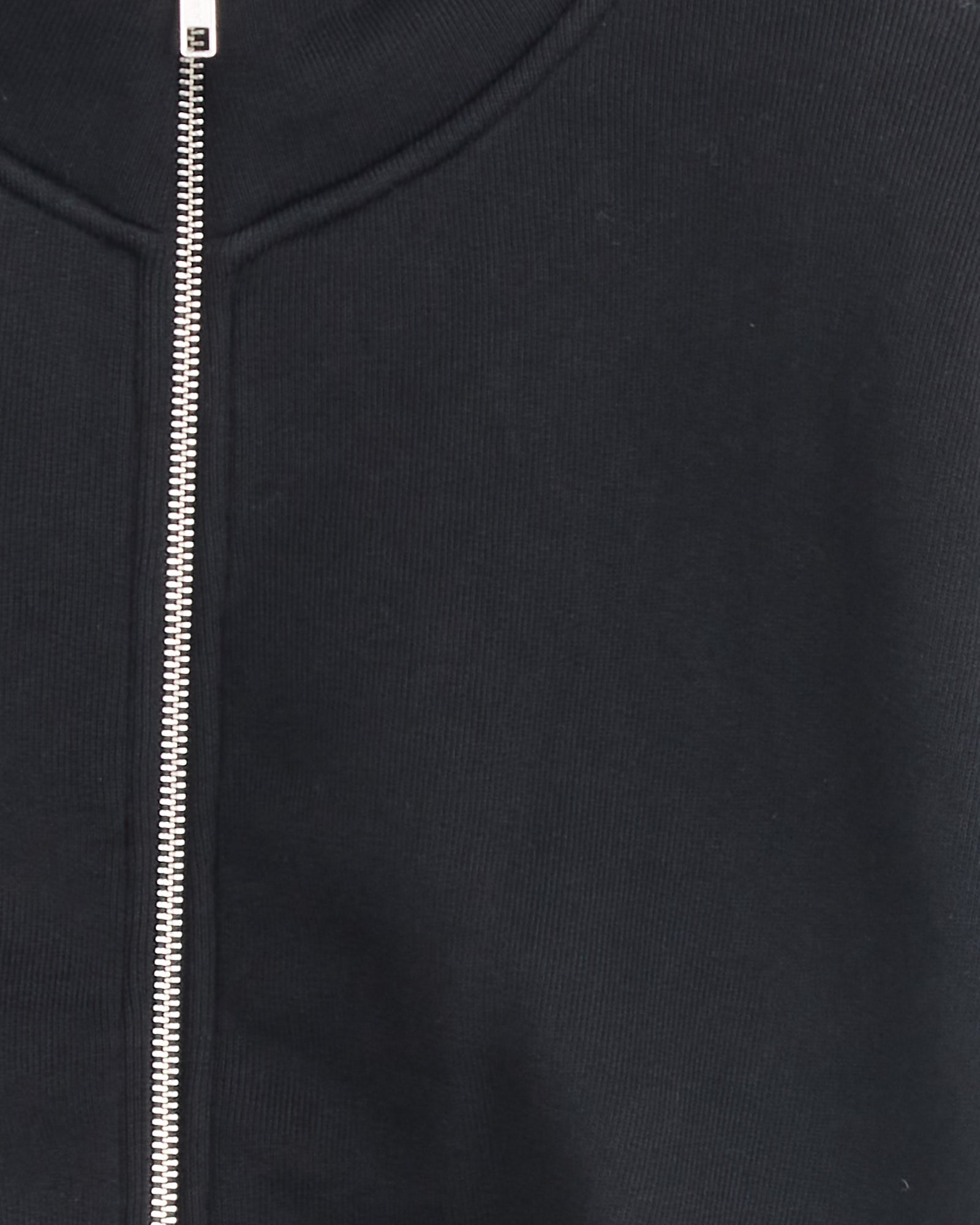 Close-up of the upper section of the AGOLDE Asta Zip Sweatshirt in Washed Black, featuring a silver zipper down the center and a ribbed collar. For sizing or fit questions, reach out via our online chat.
