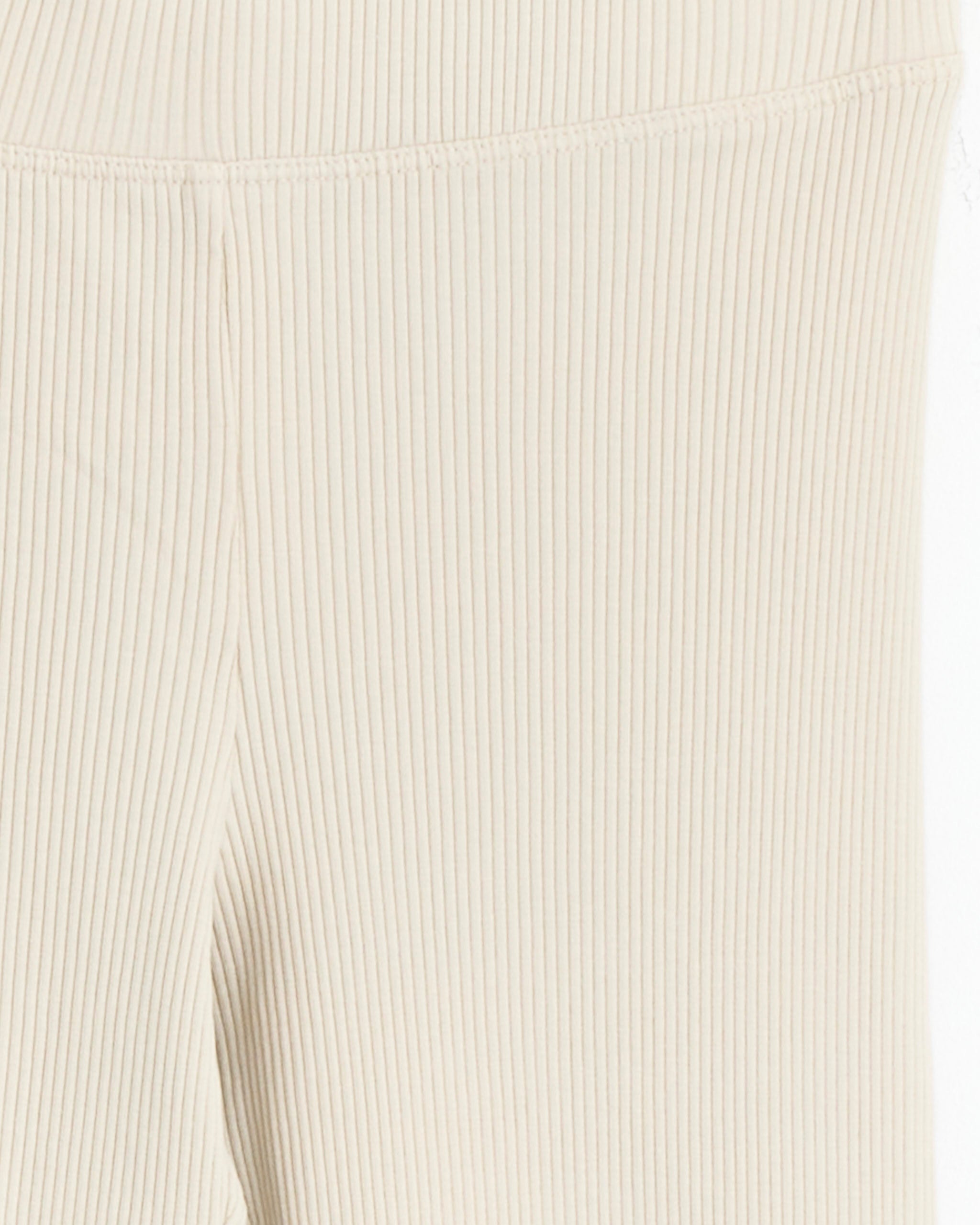 Close-up of Lauren Manoogian Ruffle Rib Leggings in Greige. Features vertical ribbed texture and visible seam at the waistband, highlighting material and stitching details. Expertly crafted and MADE IN PERU.