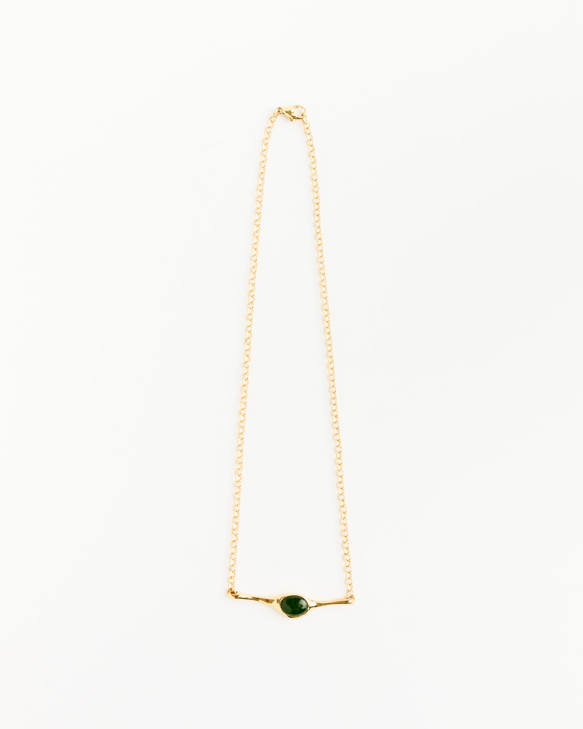 The Faba Necklace by Faris features a small, round jade pendant set in a simple gold-plated bronze bezel, shown on a white background.