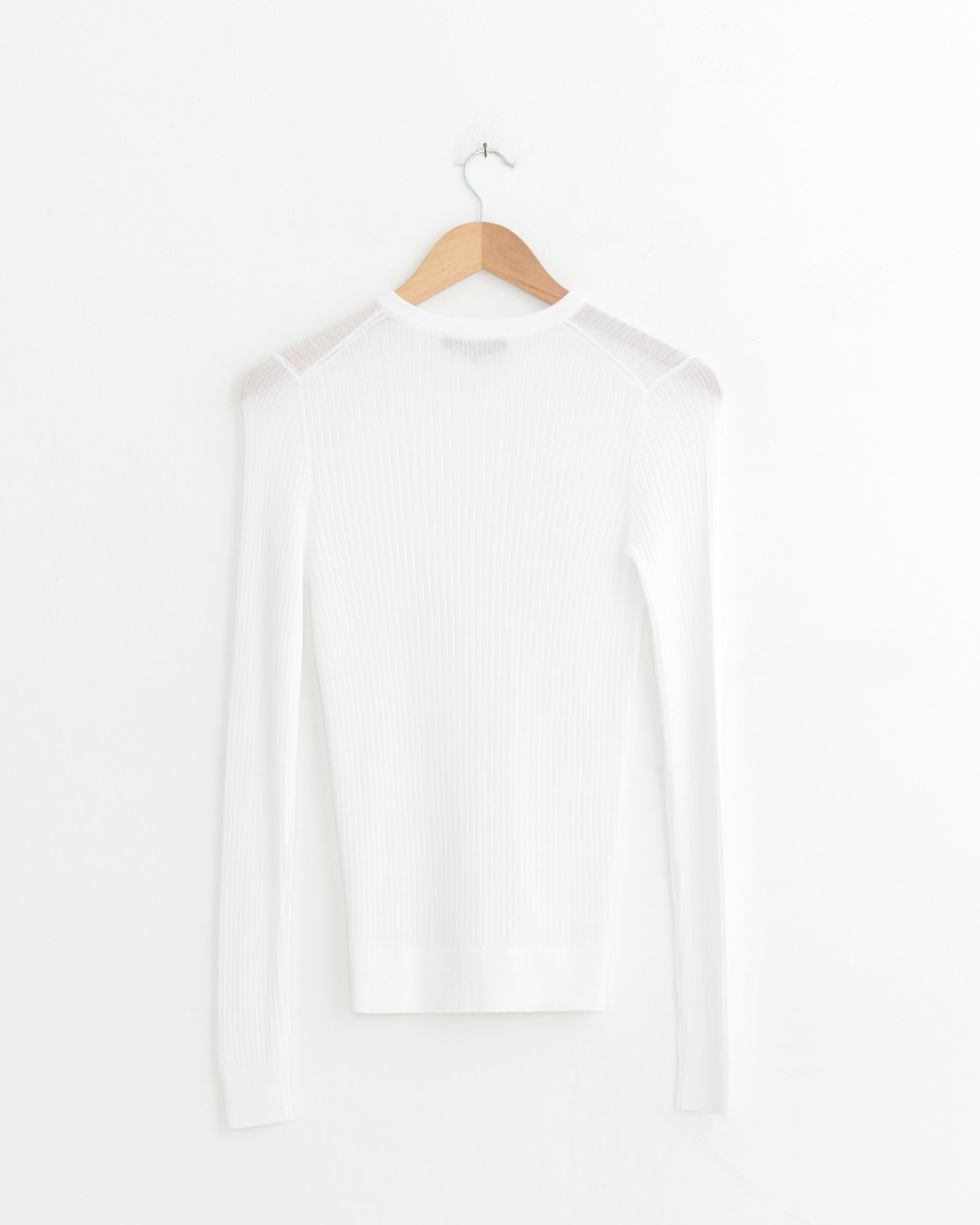 The Tibi Ribbed Sweater Slim Cardigan in White, featuring long sleeves and a fitted knit design, is displayed on a wooden hanger against a white background.