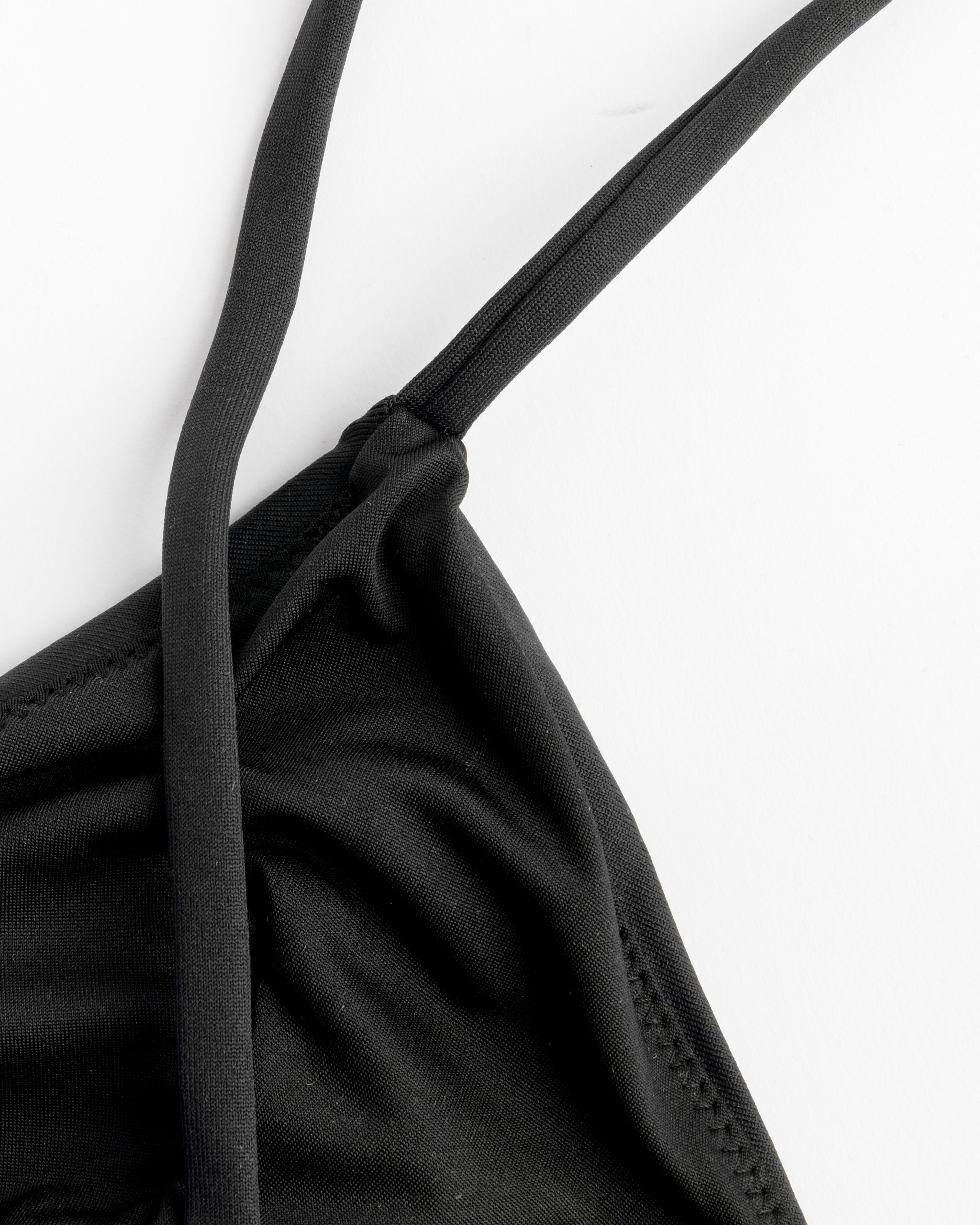 Close-up of the Baserange Mississippi Swim Top in Black, featuring thin straps and a minimal silhouette, set against a white background.