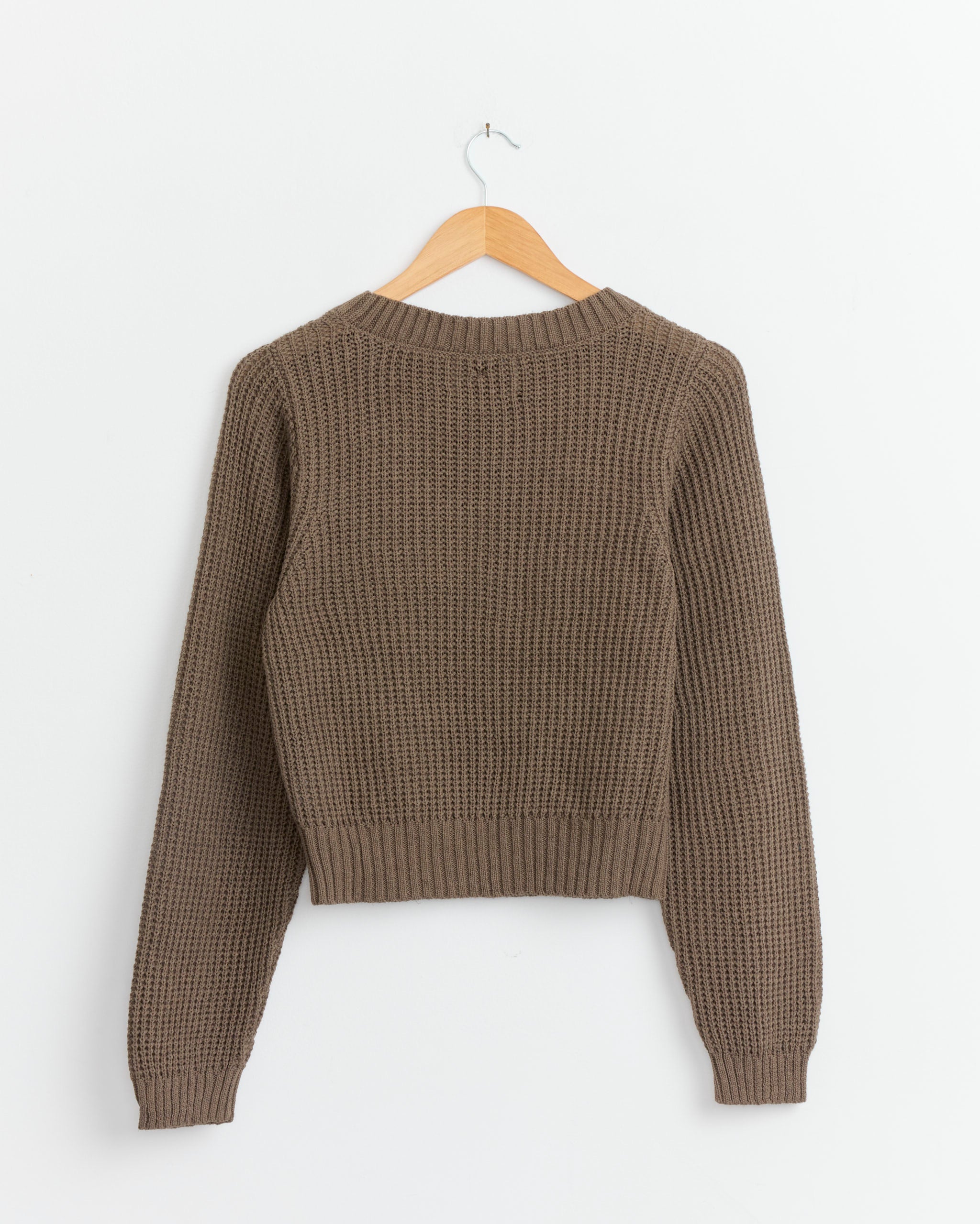 The Shaina Mote Waffle Crewneck in Bark is a lightweight, long-sleeve sweater with ribbed hem and cuffs, shown from the back on a wooden hanger against a white background.