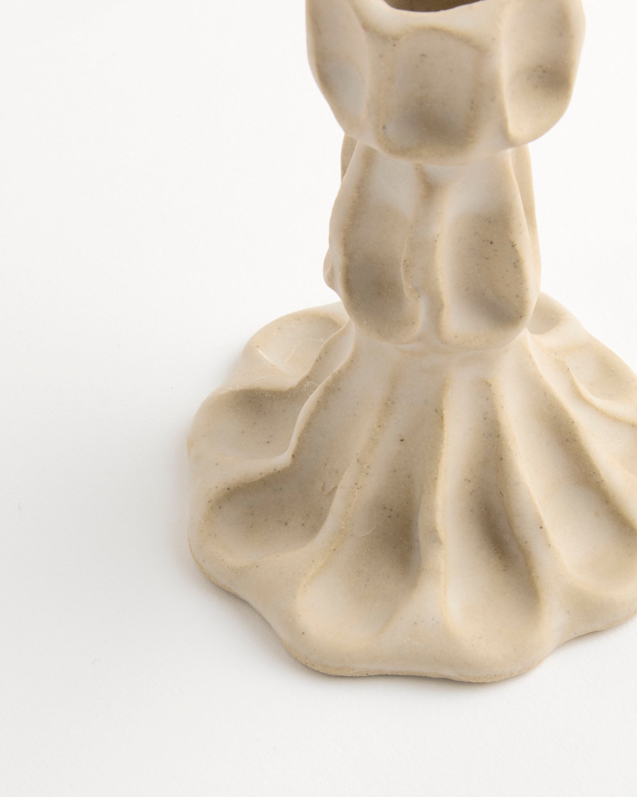 A close-up of the base of the Small Candle Stick by Carma Ferrier Ceramics, showing its beige wavy textured ceramic design against a white background.