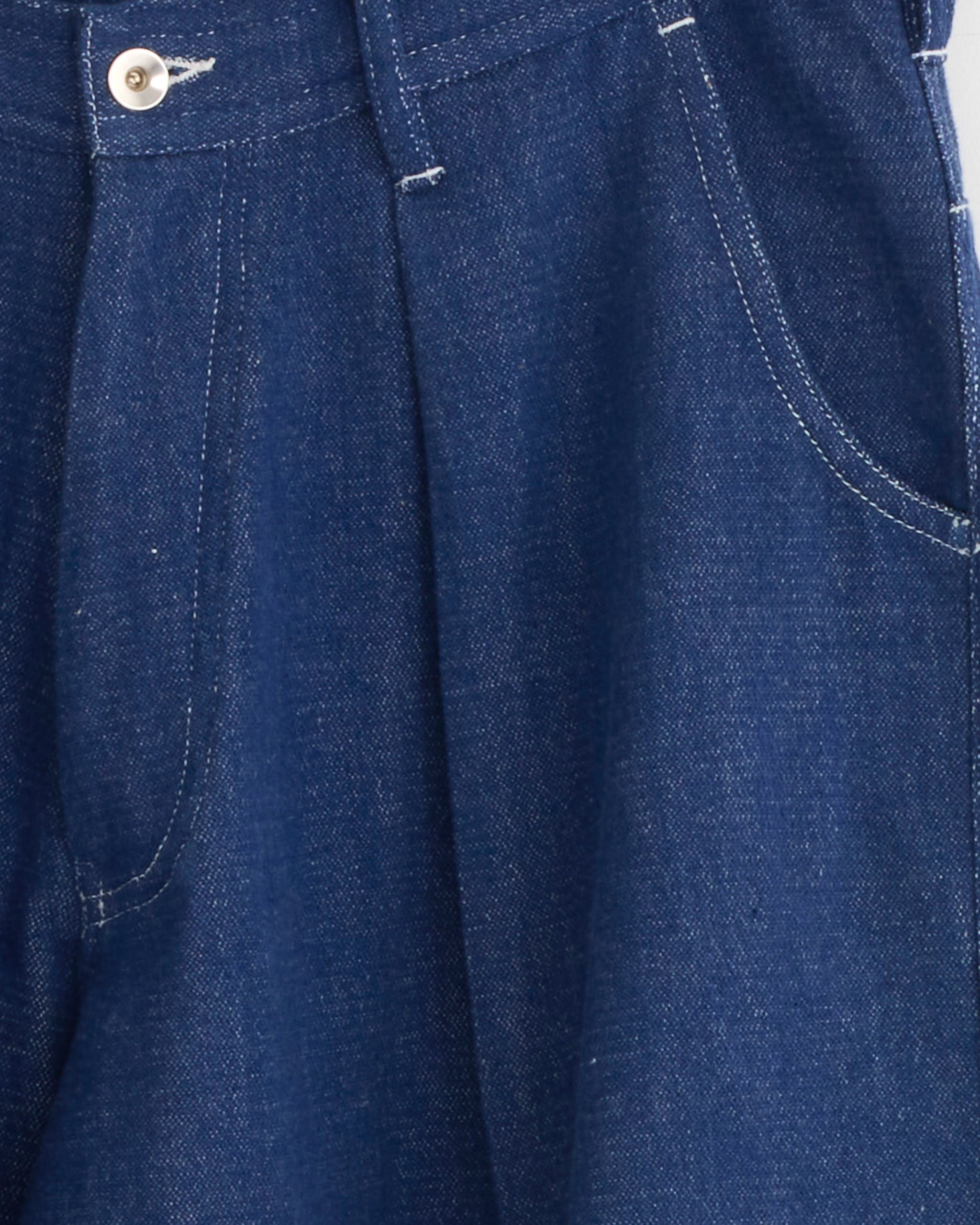 Close-up of the Lush Jean in Handloom Denim by Story mfg, featuring organic cotton fabric with waistband, button, front pocket, and visible white stitching details.