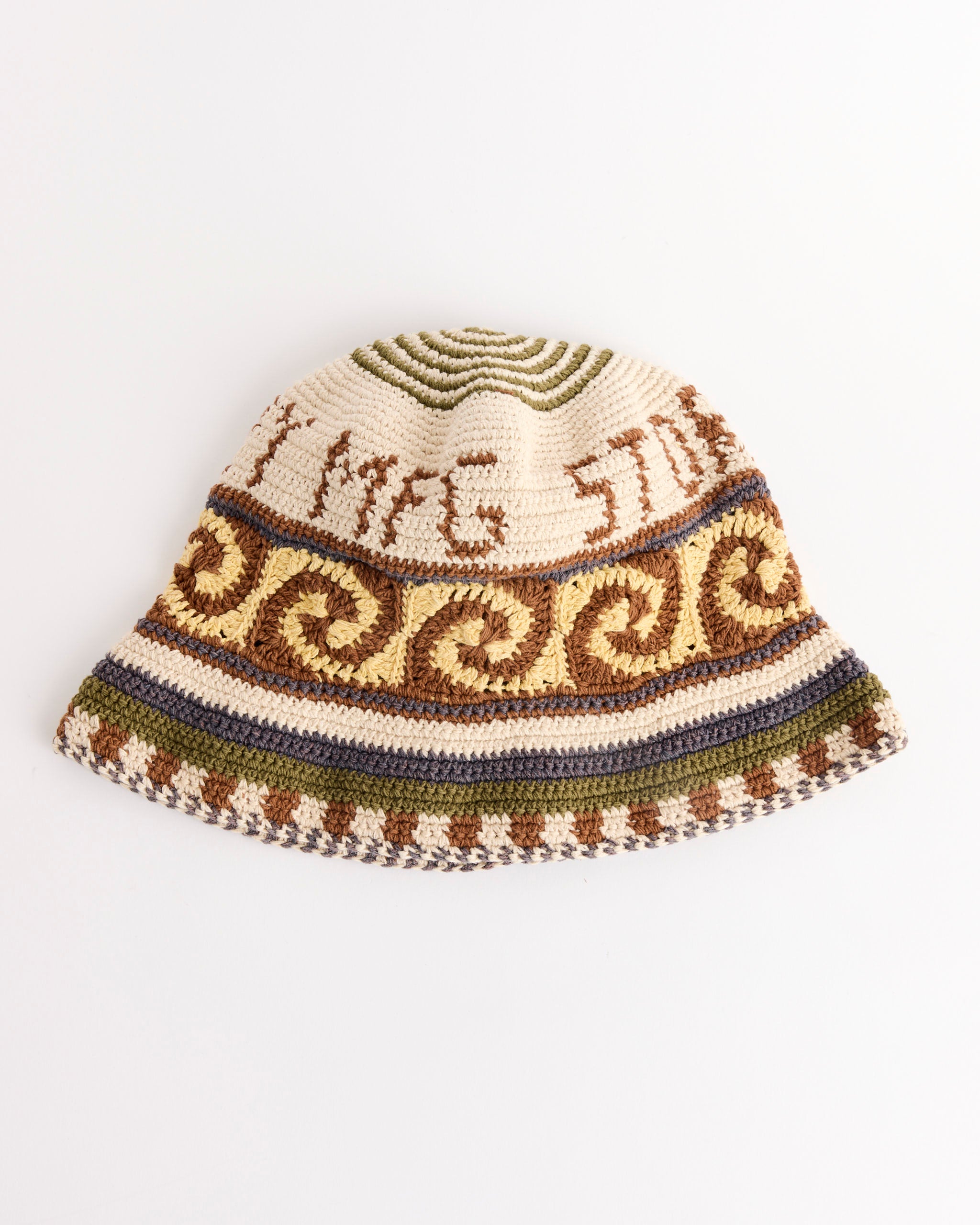 The Story mfg Brew Hat in Olive Spiral, a crocheted bucket hat made from organic cotton with cream, brown, green, and blue spiral patterns and decorative crown and brim borders, is shown laid flat on a white background.
