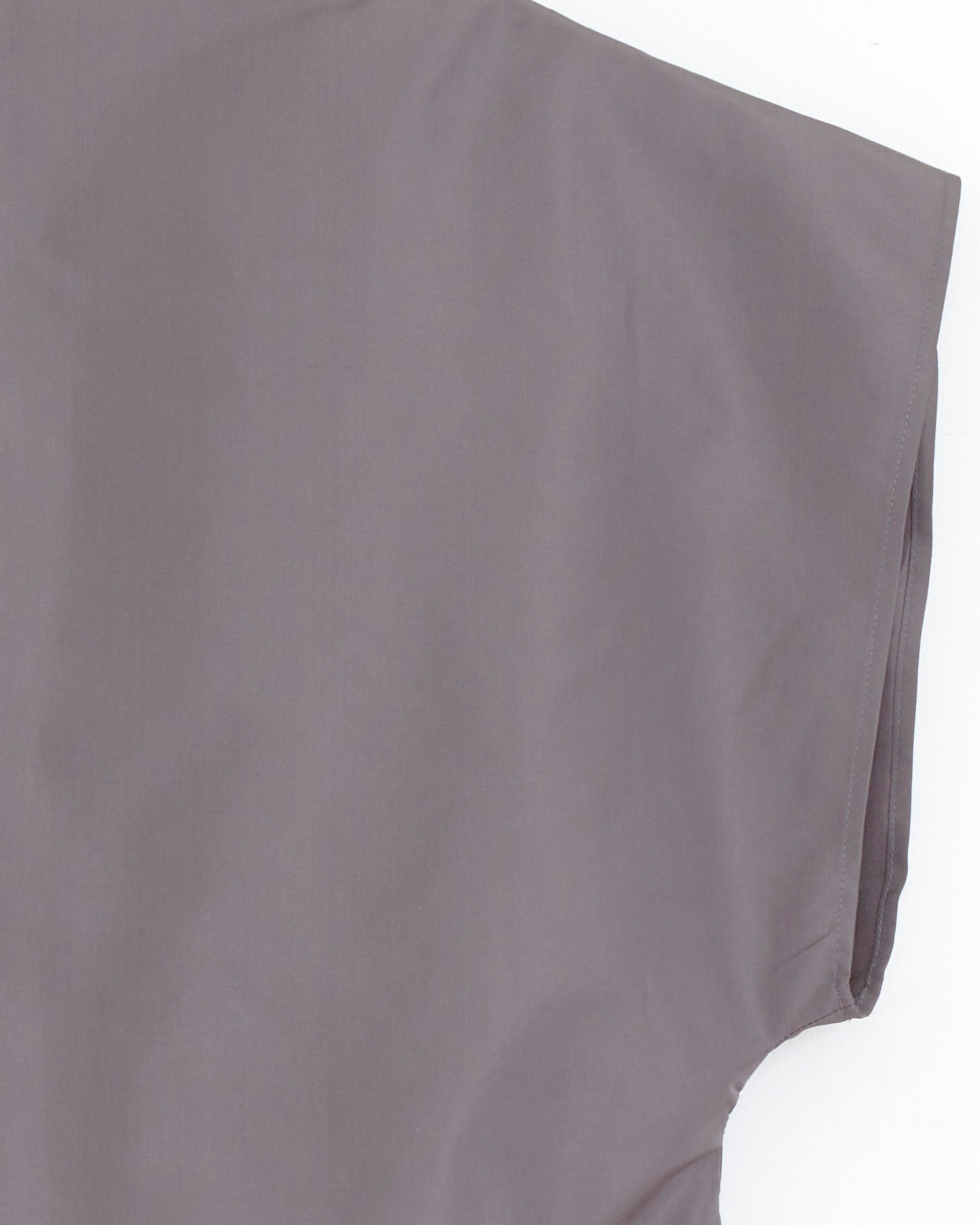 Close-up of the upper section of the Chelsea Mak Luca Shell Top in Metal silk taffeta, laid flat on a white surface, showing the sleeve, shoulder, and part of the side seam.
