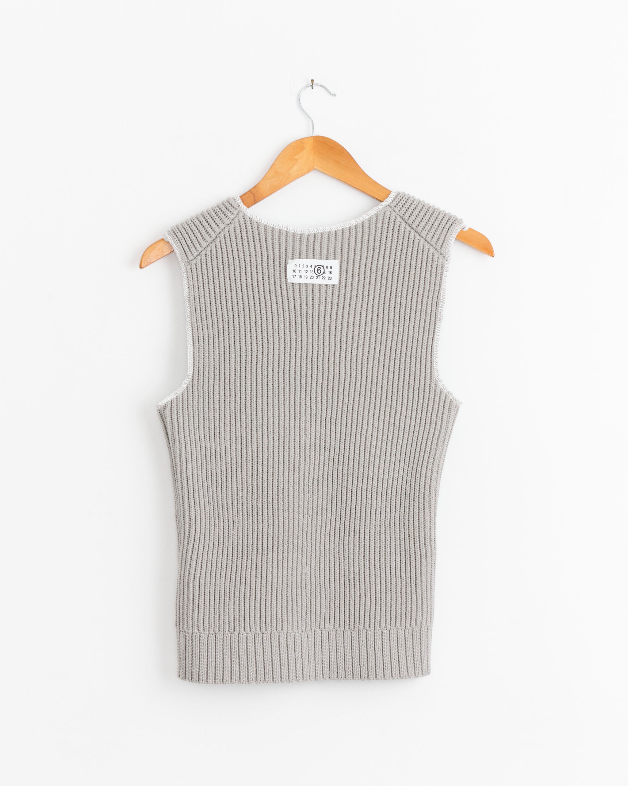 The Ribbed Top in Grey by MM6 Maison Margiela is shown sleeveless on a wooden hanger against a white background, highlighting its ribbed texture.