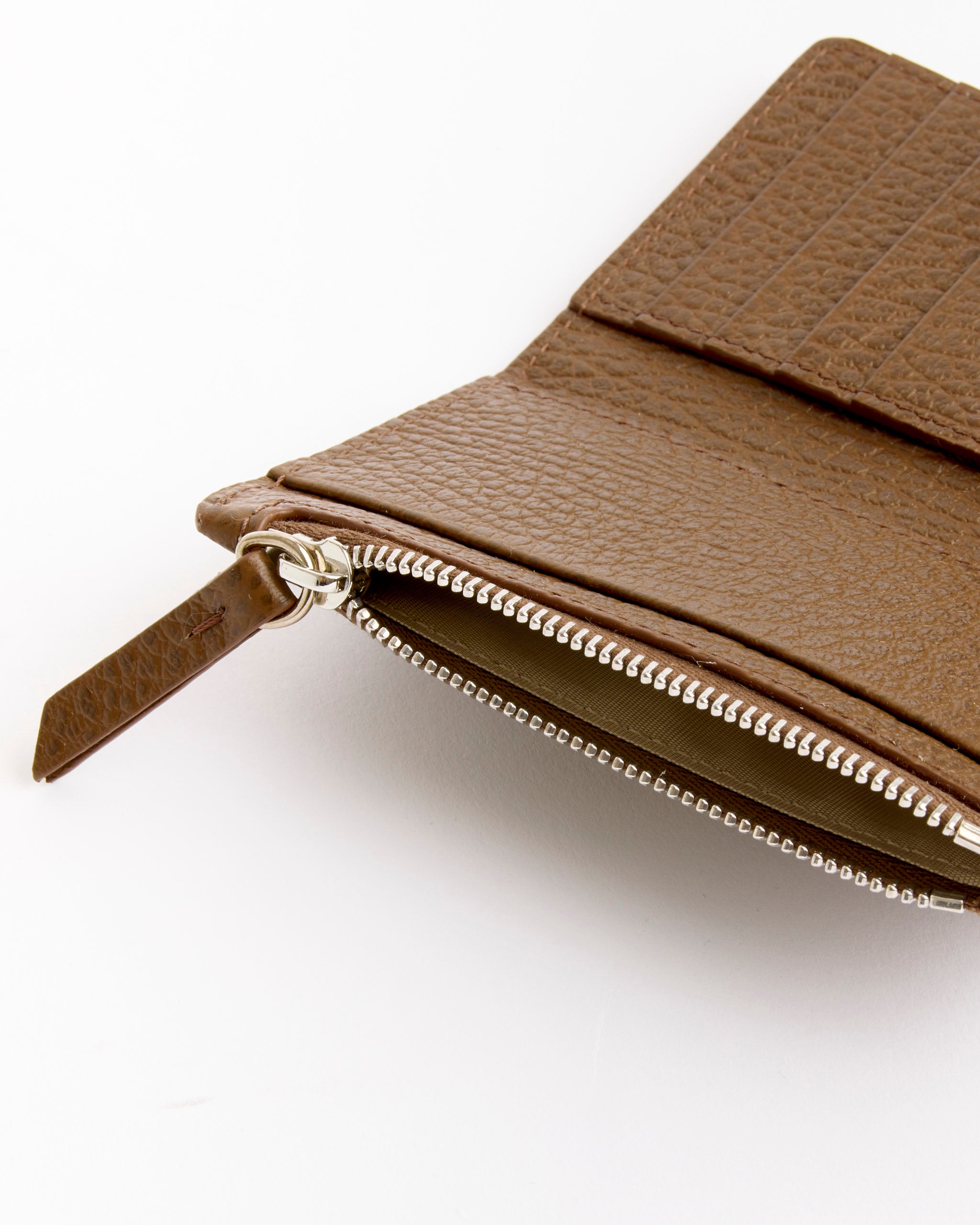Close-up of the Maison Margiela Card Holder Clip 2 With Zip Wallet in Field, featuring a brown leather finish, silver zipper, and card slots—an elegant choice for those seeking a refined zip wallet or card holder.