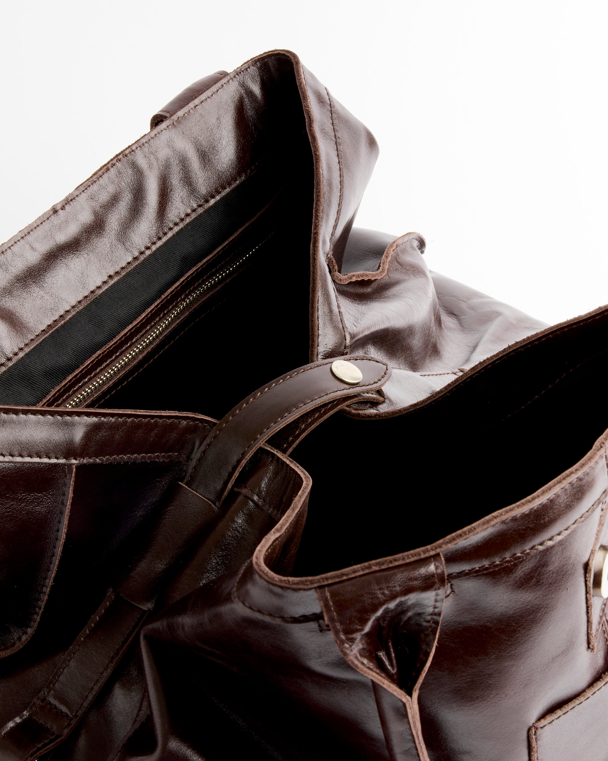Close-up of the Big Guida Bag in Brown by Paloma Wool, showing visible stitching, interior lining, and a zippered pocket inside. Crafted in España from 100% leather and set against a white background.