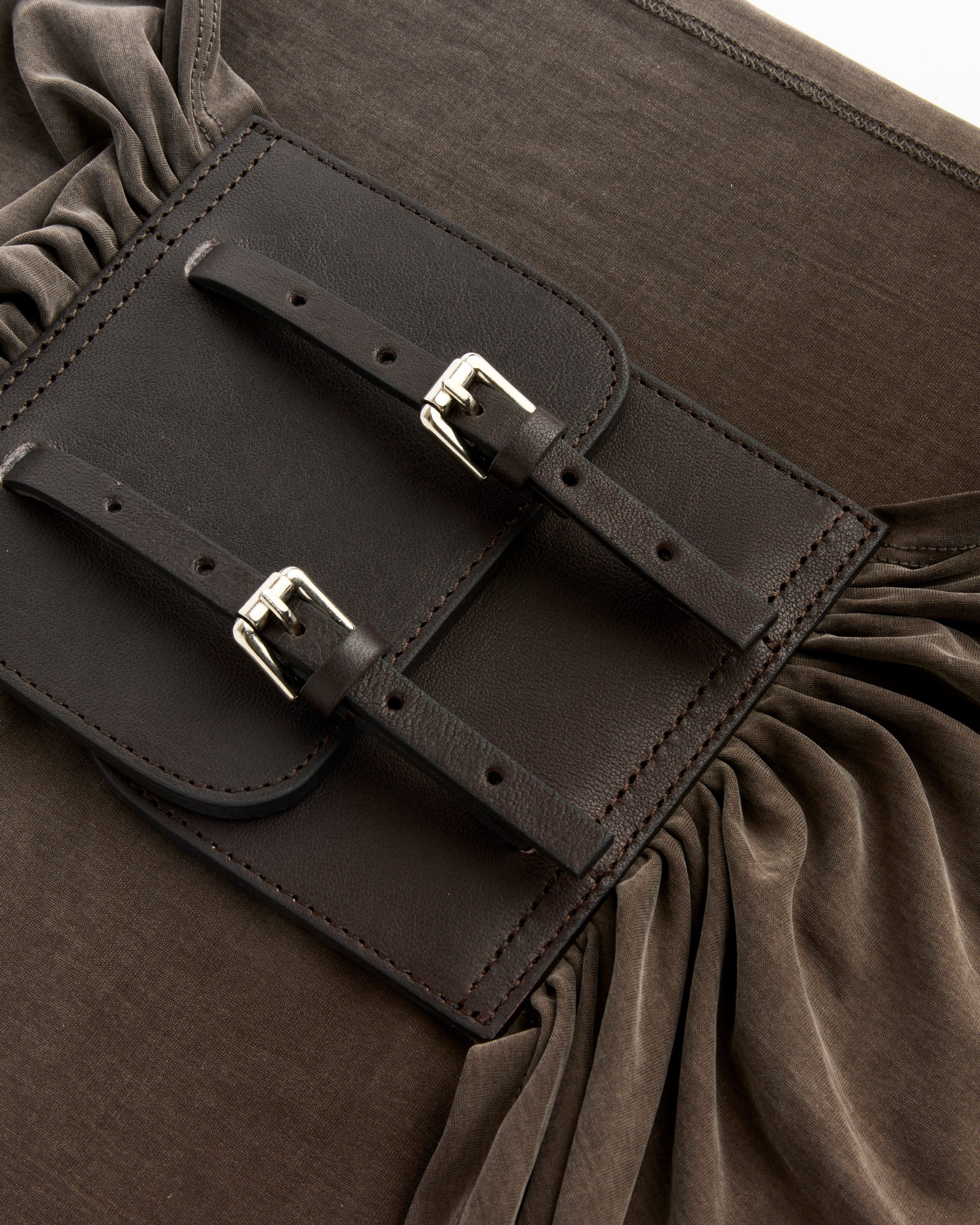 Close-up of the Paloma Wool Adriana II Belt in Multi, featuring a rectangular dark brown leather double buckle patch with two buckled straps and ruched fabric details on either side.