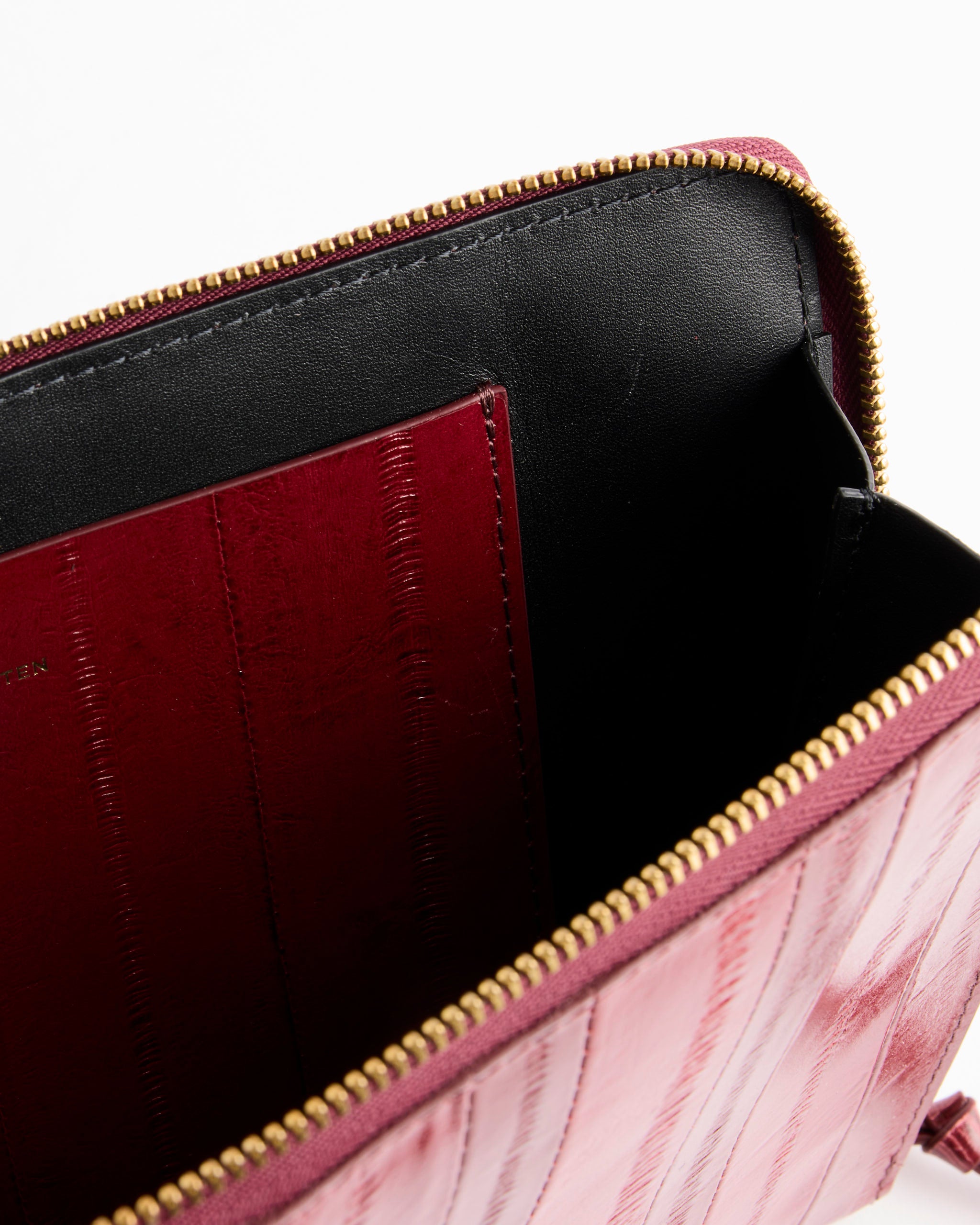 Close-up of the inside of the Dries Van Noten Pouch in Red, featuring a black lining and interior red pocket, with a gold zipper—expertly crafted in Italy.