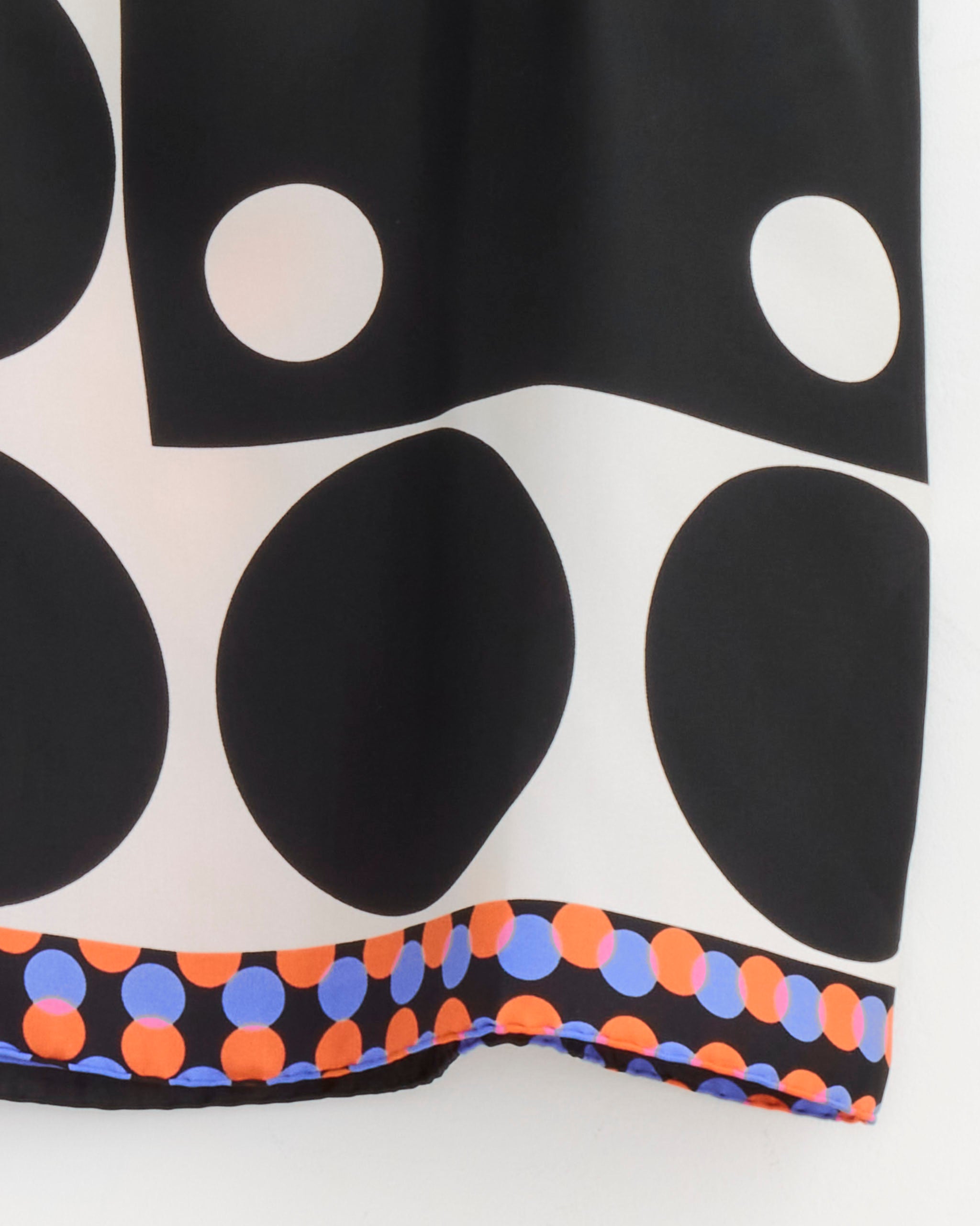A close-up of the Dries Van Noten Scarf Skirt in Dessin A shows bold geometric patterns—large black circles, white dots, and a border of small orange and blue circles—ideal for a striking graphic print midi or silk wrap skirt.