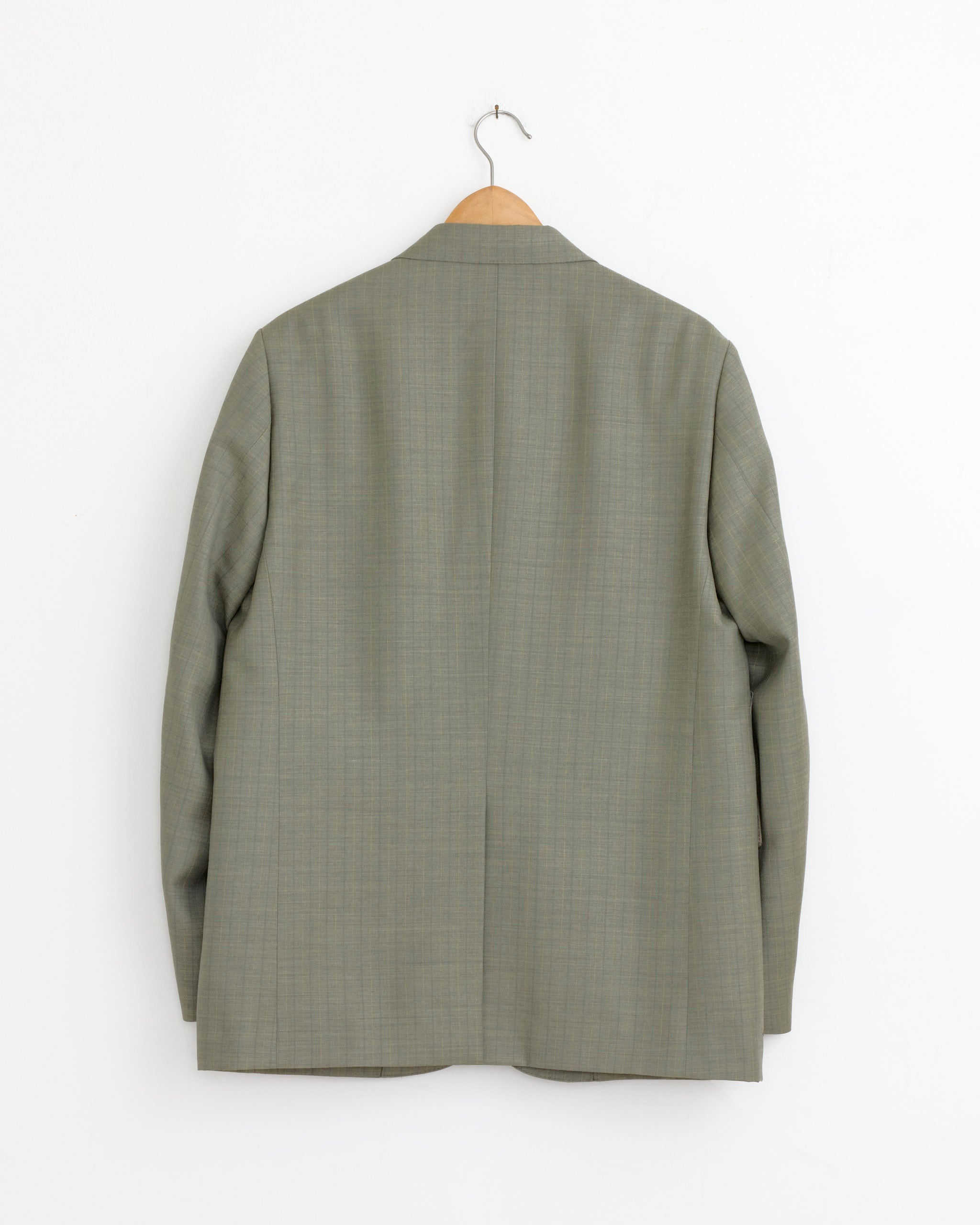 An Auralee Bluefaced Wool Stripe Jacket in Khaki Grey hangs on a wooden hanger against a plain white wall, shown from the back.