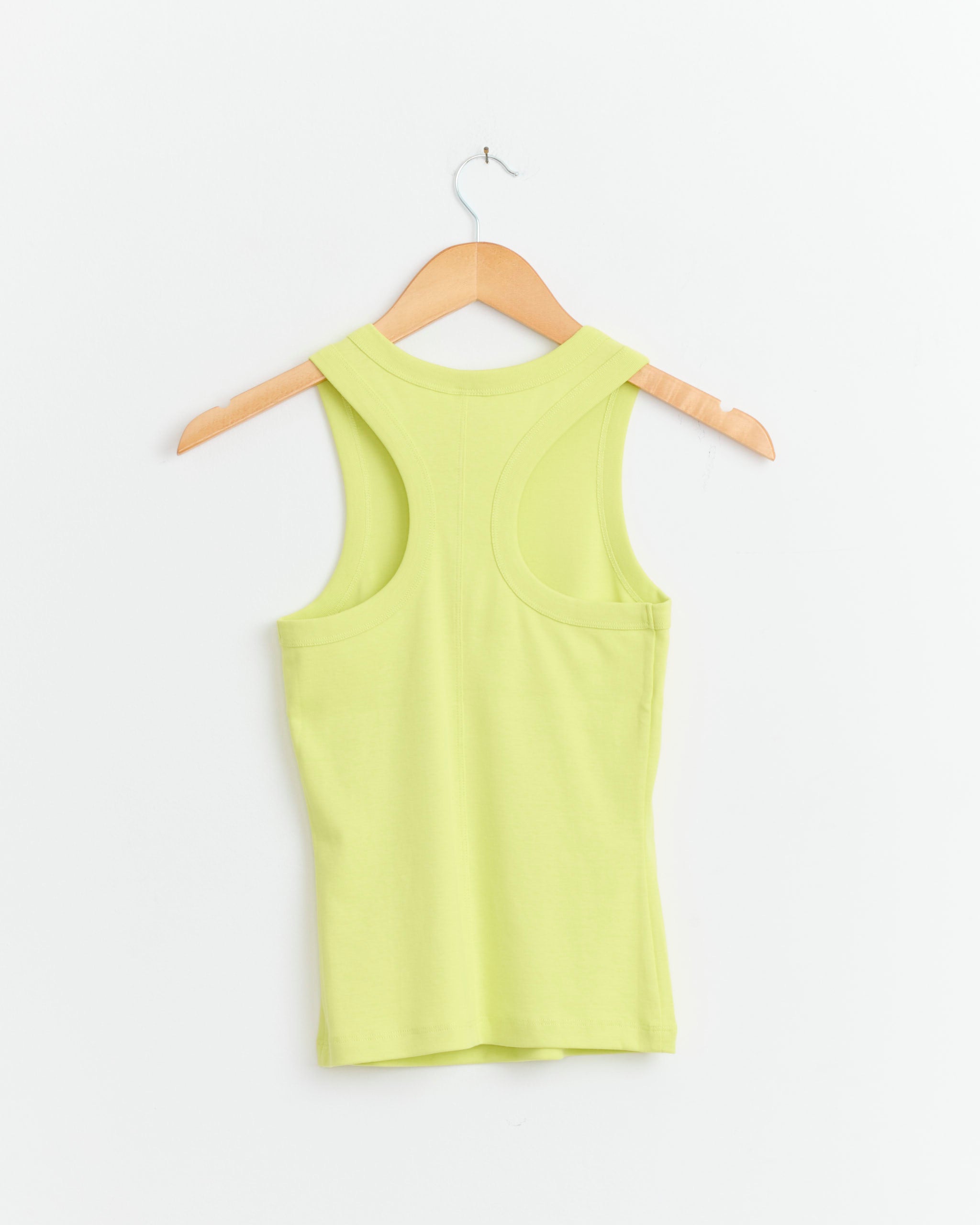 The FLORE FLORE Hannah Tank in Lime is shown from the back on a wooden hanger against a white background.