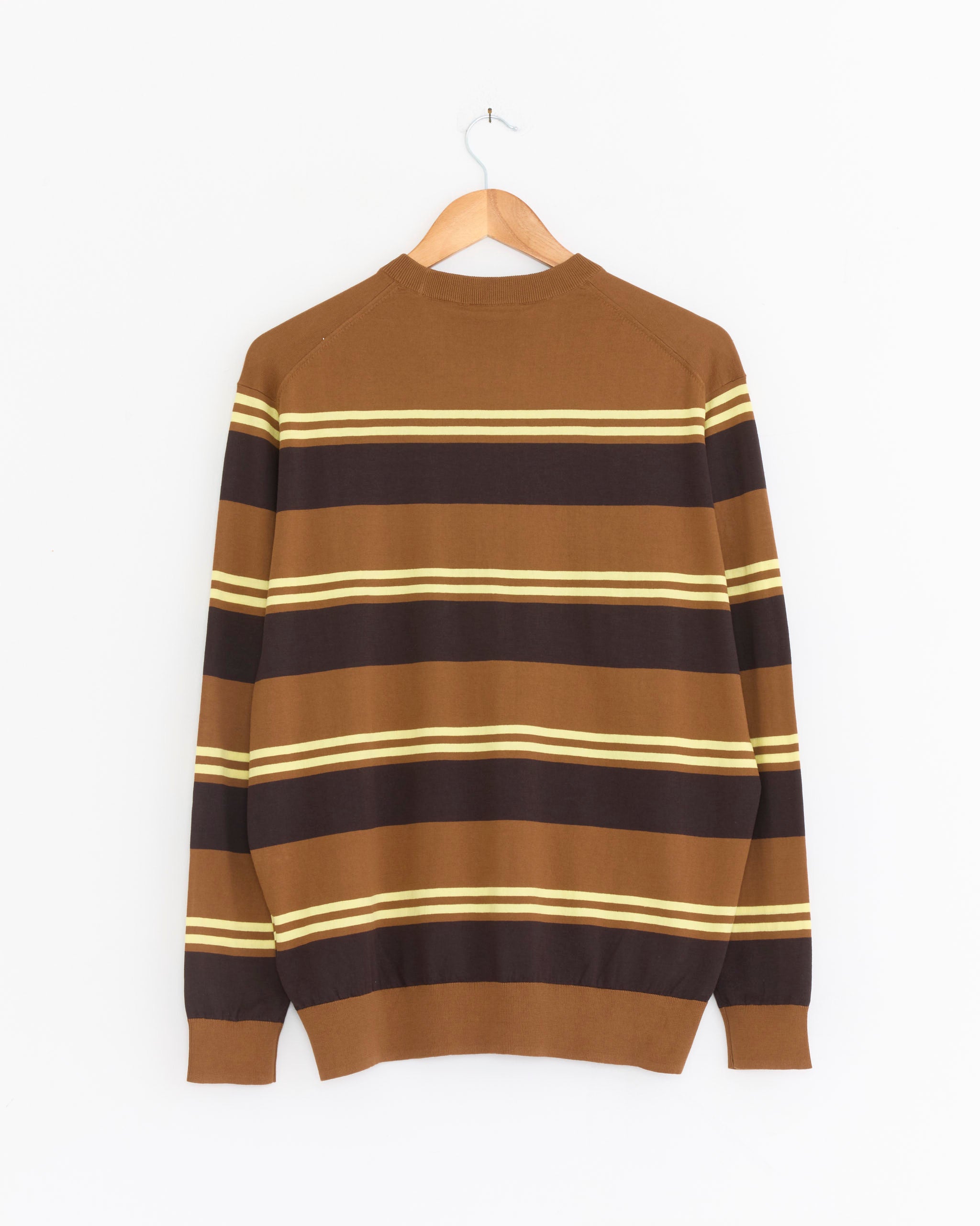 The Tibi Striped Perfect Crewneck in Brown Multi, featuring black, yellow, and tan stripes, hangs on a wooden hanger against a white background. This lightweight cotton sweater is shown from the back.