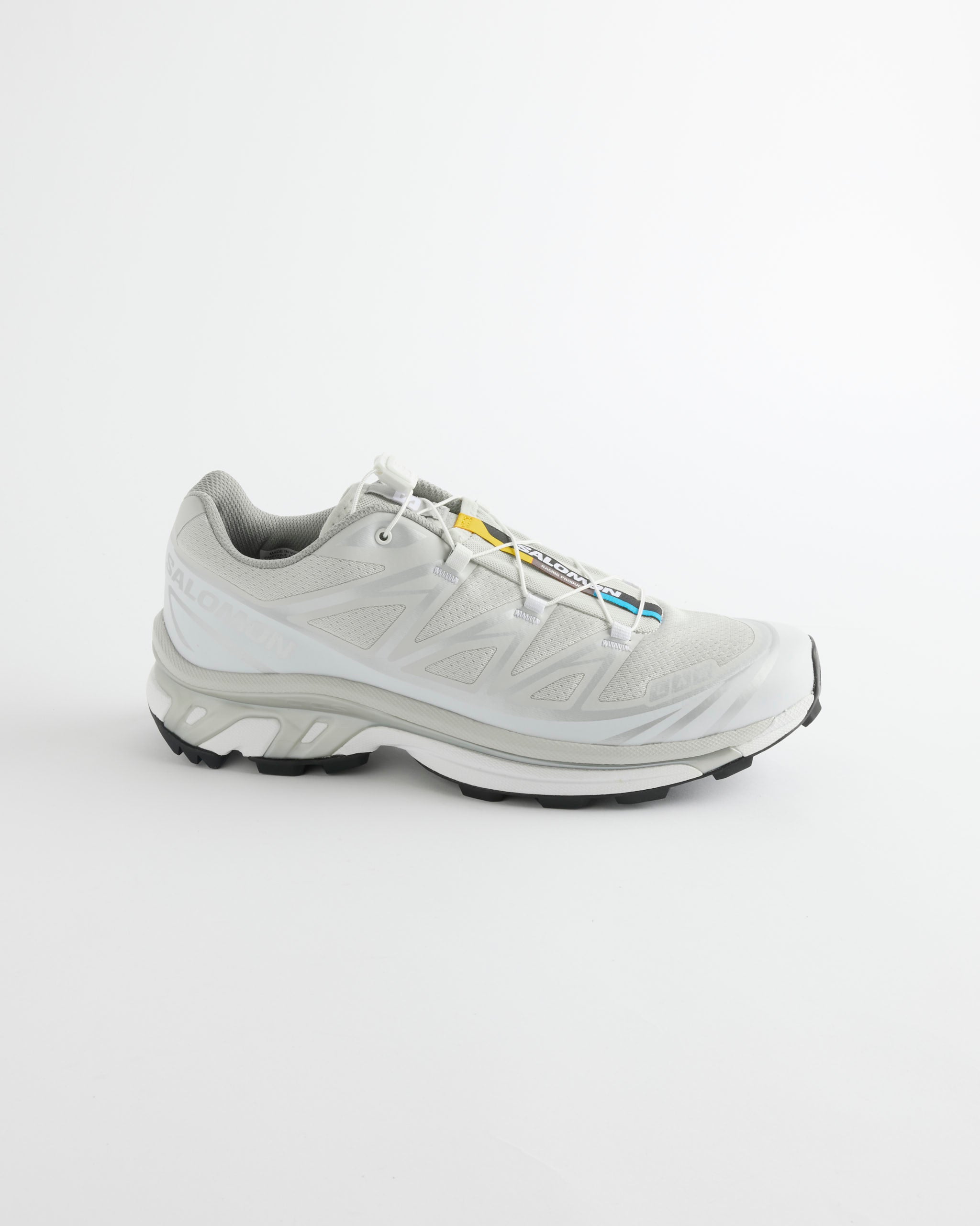 The Salomon XT-6 in Lunar Rock/Ftw Silver/White is an athletic shoe featuring a white base with gray accents, a black sole, and a quick-lace system, displayed on a plain white background.
