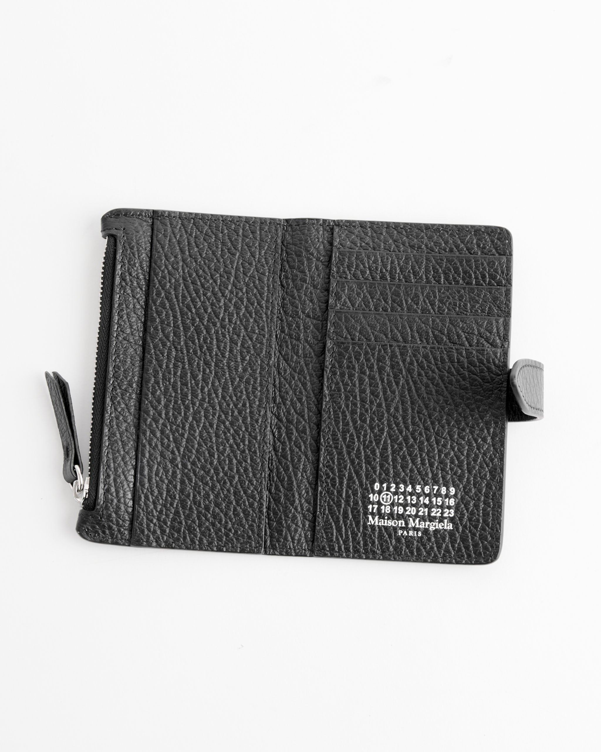 The Maison Margiela Card Holder Clip 2 With Zip in Black is open on a white surface, showing card slots, a zippered coin pocket, and the signature numbered logo printed in white inside.