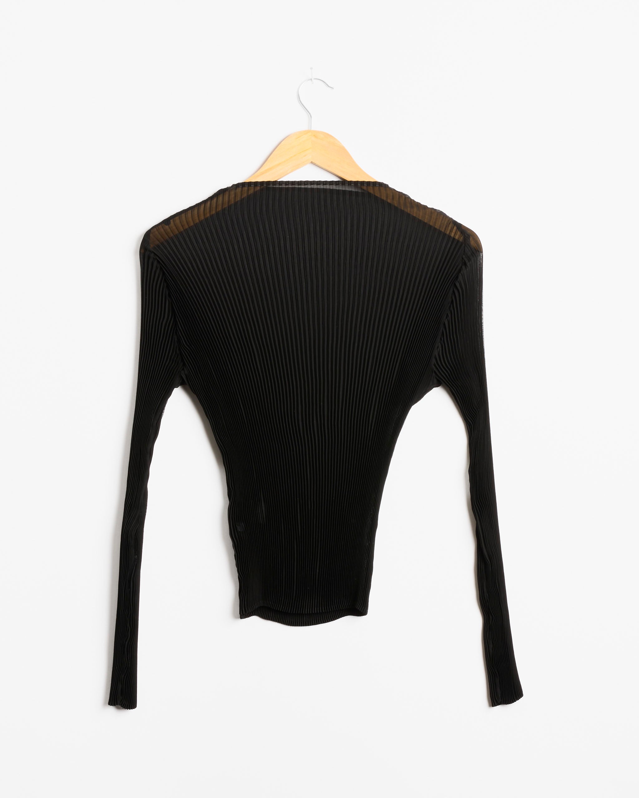 The Lee Top in Monochroms Black by Julia Heuer, a long-sleeve ribbed shirt, is displayed on a wooden hanger against a white background.