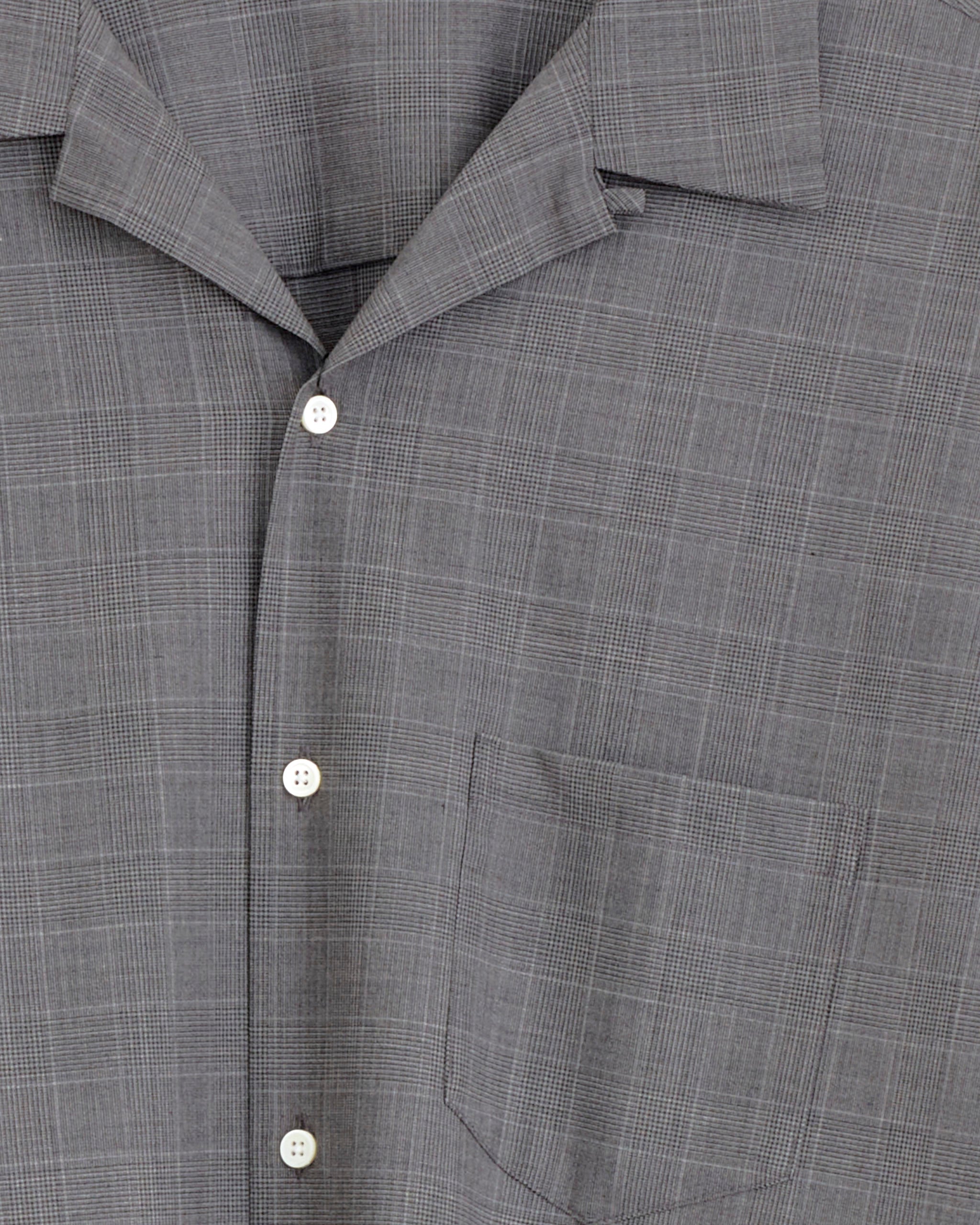 Close-up of the Sillage Re-Engineered Overshirt in Glen Check, featuring white buttons, a left chest pocket, an open collar, and a subtle checkered pattern crafted from soft tropical wool.