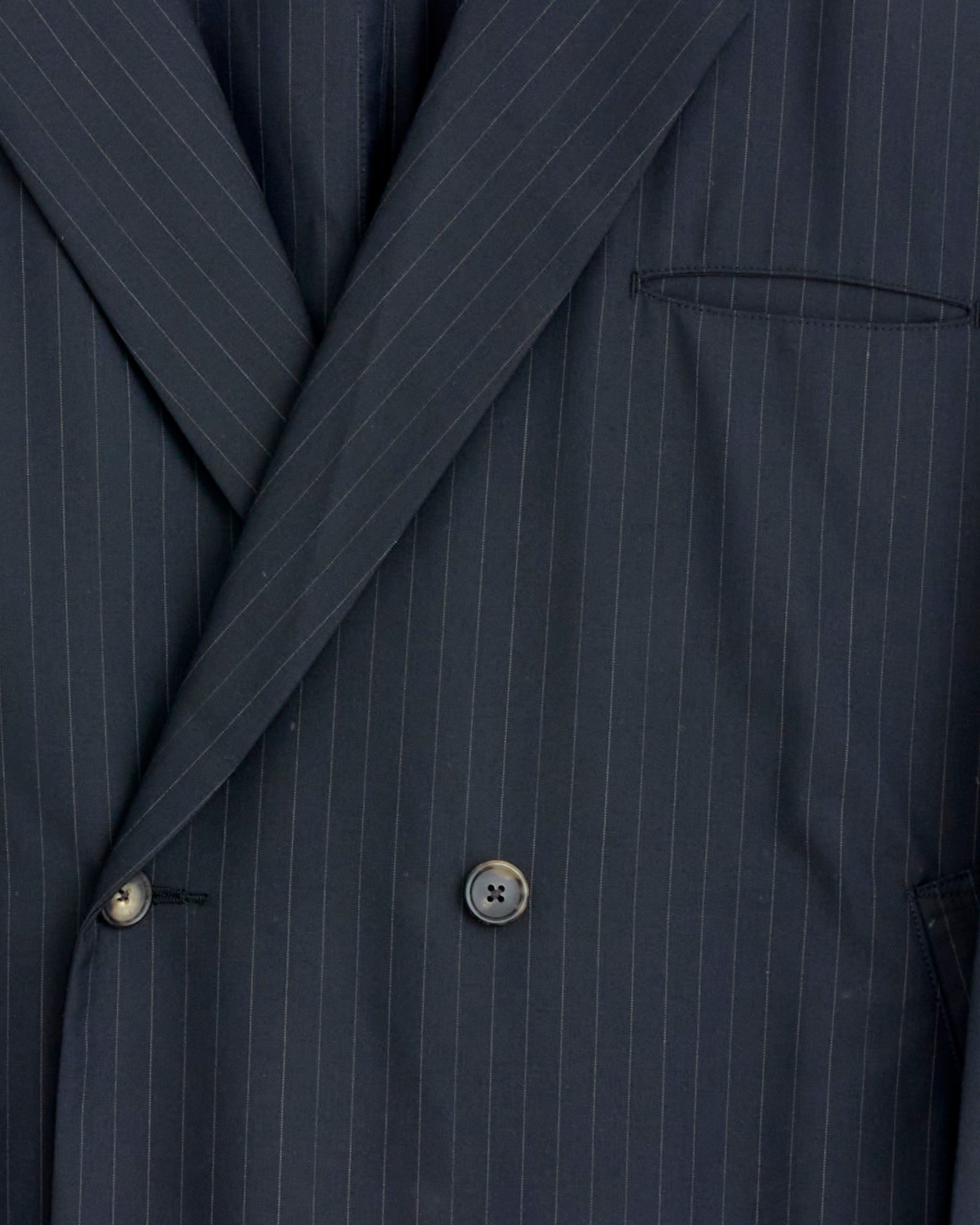 Close-up of the Sillage Double Breasted Jacket in Black Stripe, showcasing its refined lapel, two sleek buttons, and neatly tailored chest pocket.