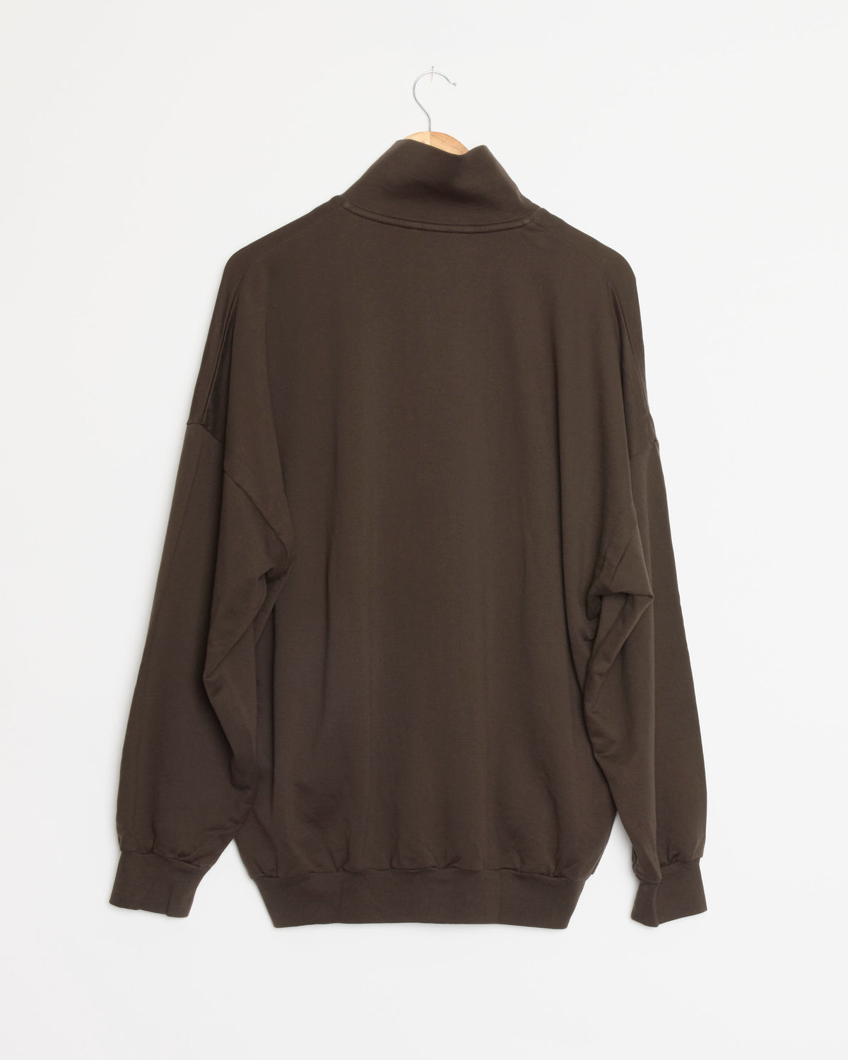 The Auralee Super High Gauge Sweat Zip Blouson in Dark Brown is a premium long-sleeve pullover sweatshirt, crafted from high-quality Pima cotton with a high collar. Shown from the back and displayed on a wooden hanger against a white background, this expertly Made in Japan piece ensures exceptional comfort and quality.