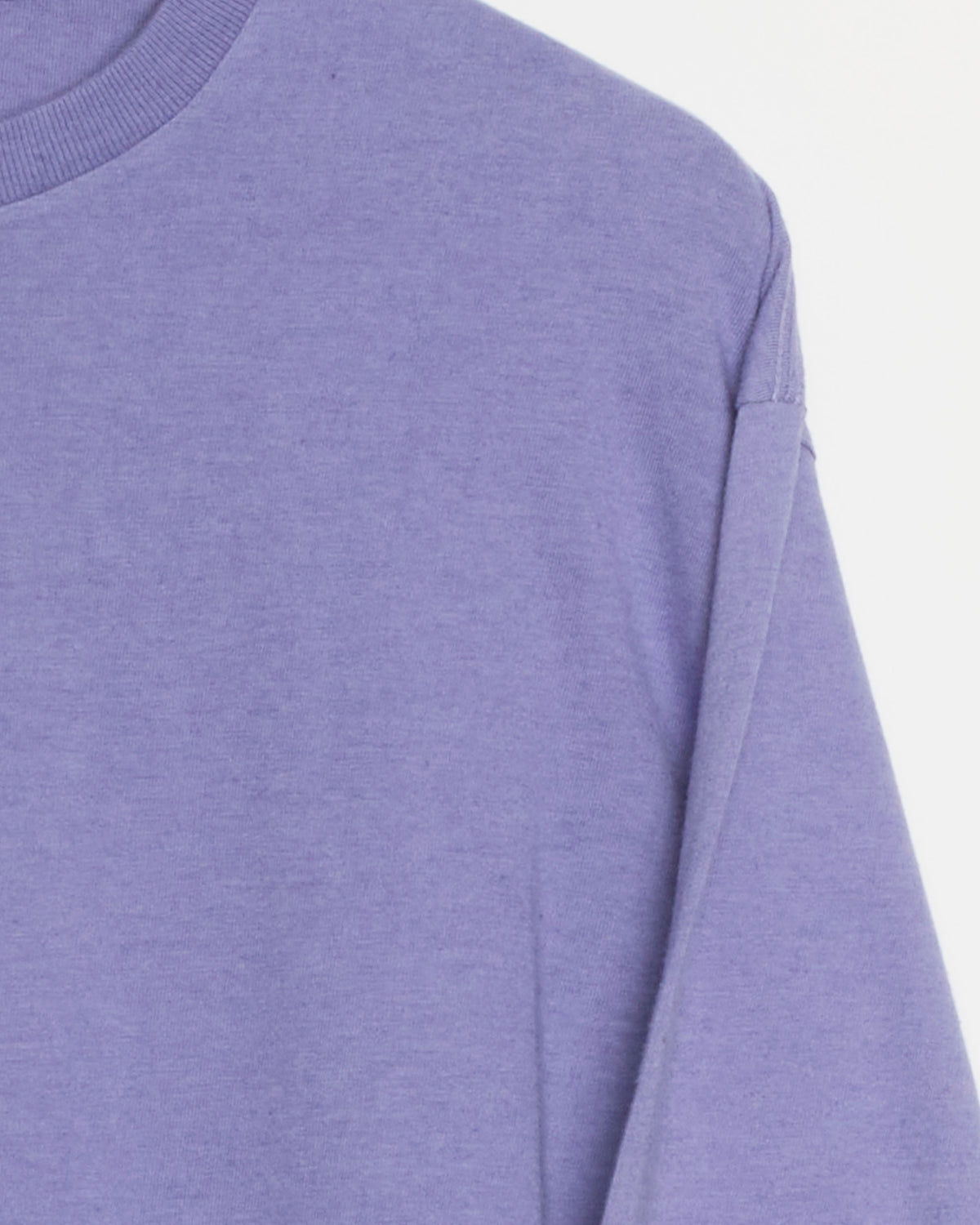 A close-up of the Auralee Brushed Cotton Jersey Tee in Light Purple, highlighting the upper chest, shoulder, and part of the sleeve against a white background. The long sleeve tee is crafted from soft brushed cotton jersey.