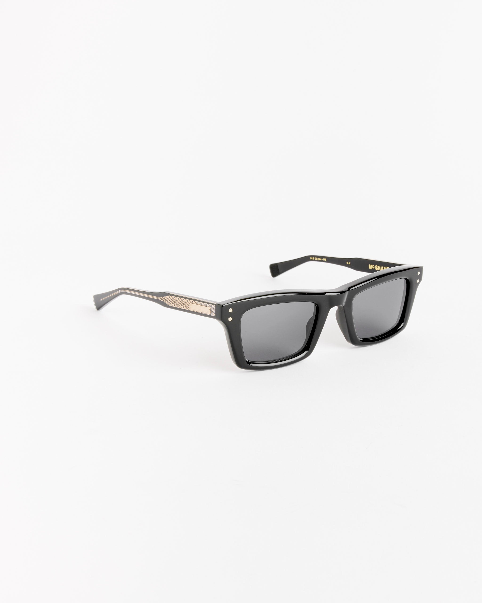 The Native Sons McShane Sunglasses in Black / GR-9 Grey feature square dark lenses, thick black acetate frames, and gold temple detailing, shown on a plain white background.