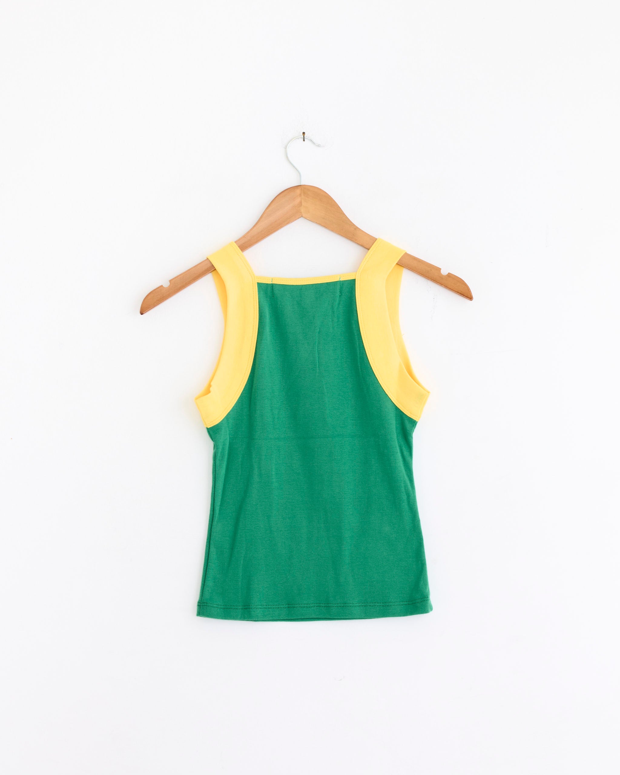 The Brazil Tank Top in Green/Yellow by Made Some Sportswear is a vintage-inspired sleeveless top with wide yellow shoulder straps, shown on a wooden hanger against a white background.