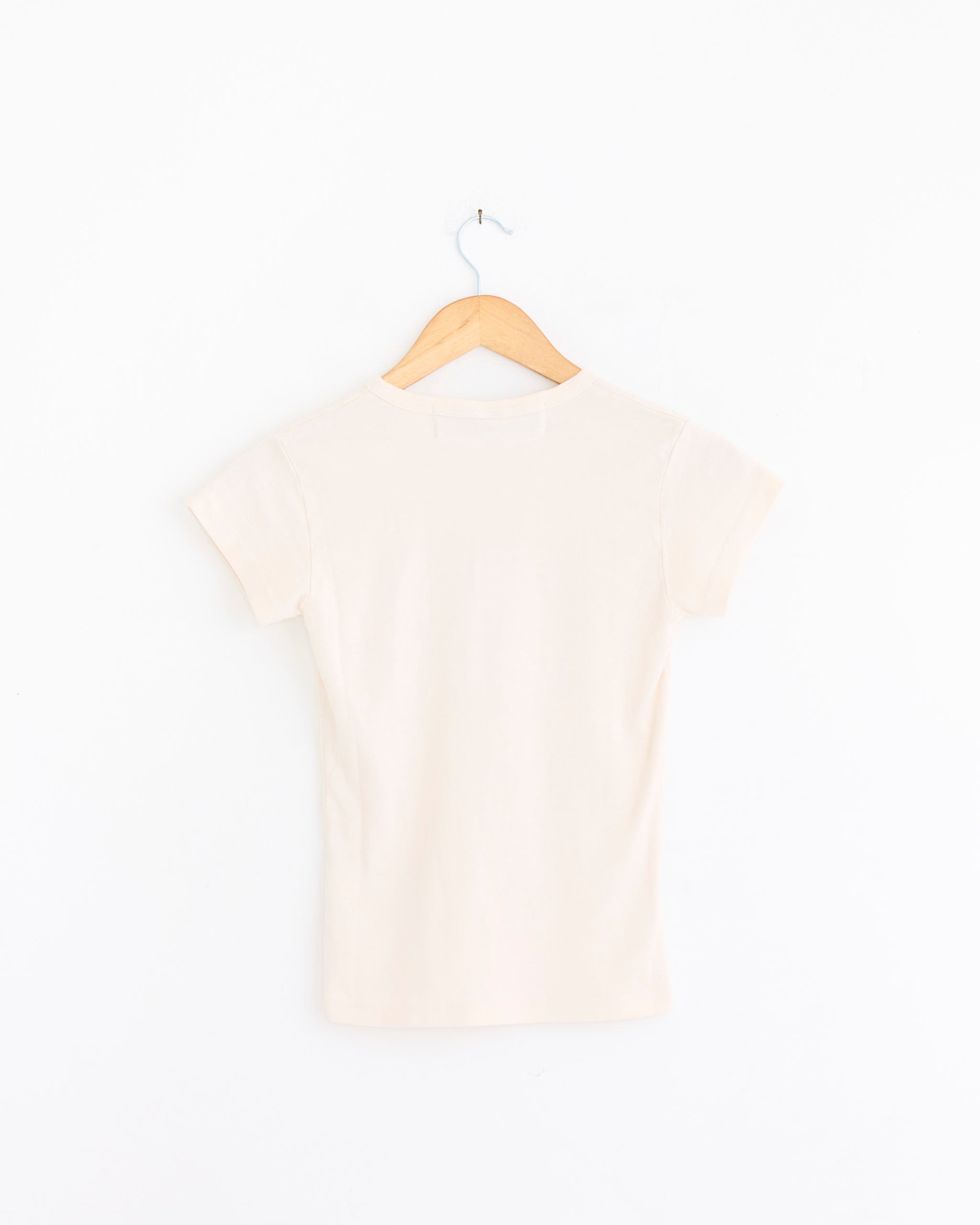 A Morocco Tee in Multi by Made Some Sportswear hangs on a wooden hanger, back facing forward against a white background. This short-sleeved tee is crafted from soft USA-grown cotton for everyday comfort.
