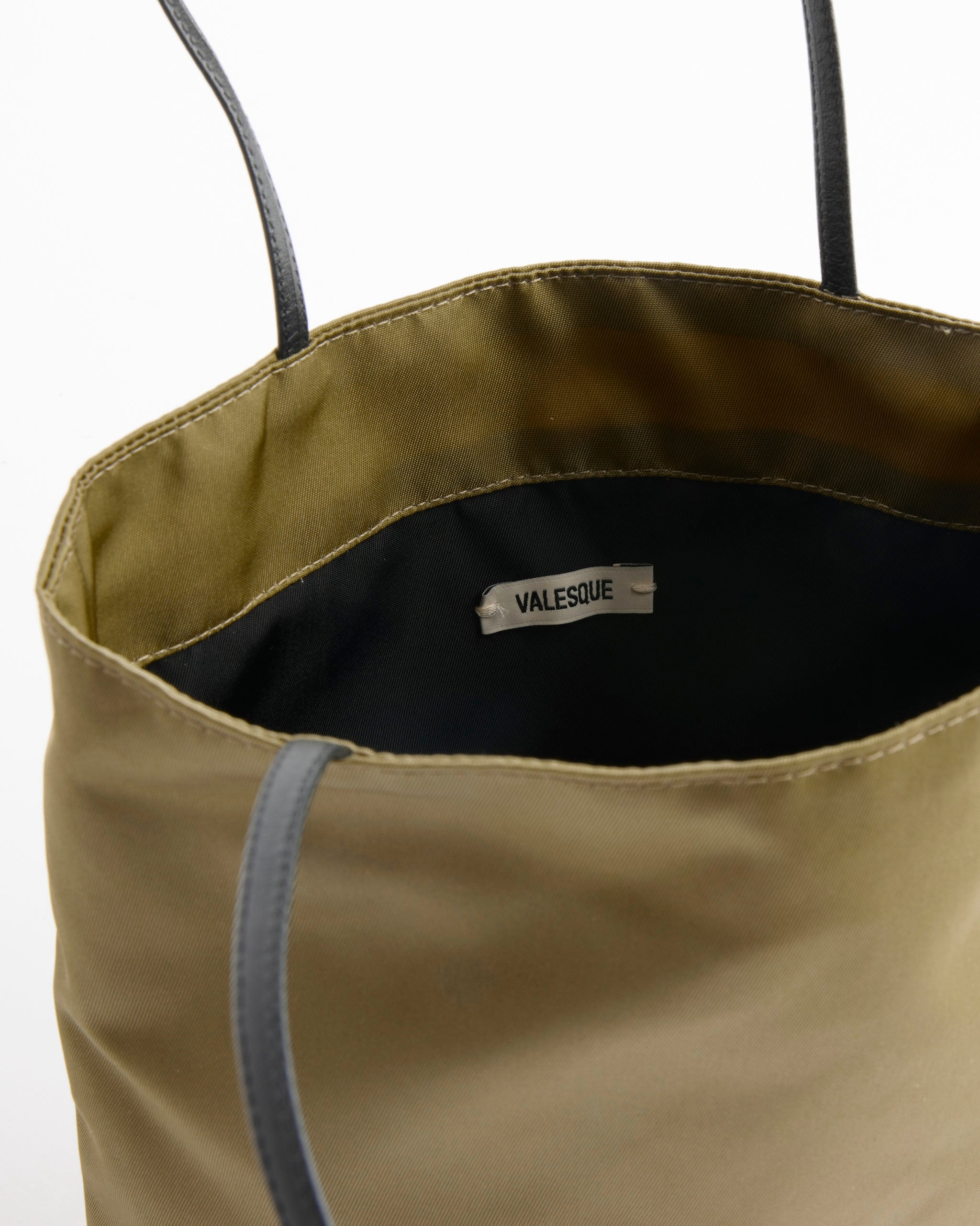 Thea Bag in Khaki by Valesque, crafted from olive green satin nylon with luxurious calf leather handles, displayed open to reveal black interior lining and the Valesque brand label.