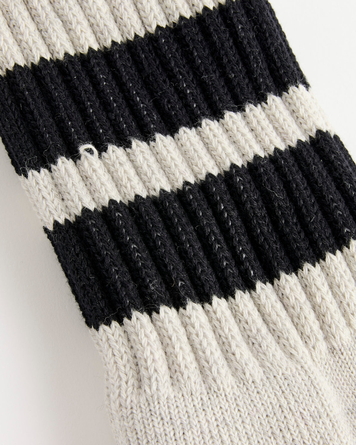 Close-up of a knitted fabric with alternating heather grey and black horizontal stripes. The texture appears thick and ribbed, suggesting it may be part of the Socks in Heather Grey/Black from Comme Des Garçons Homme, expertly made in Japan.