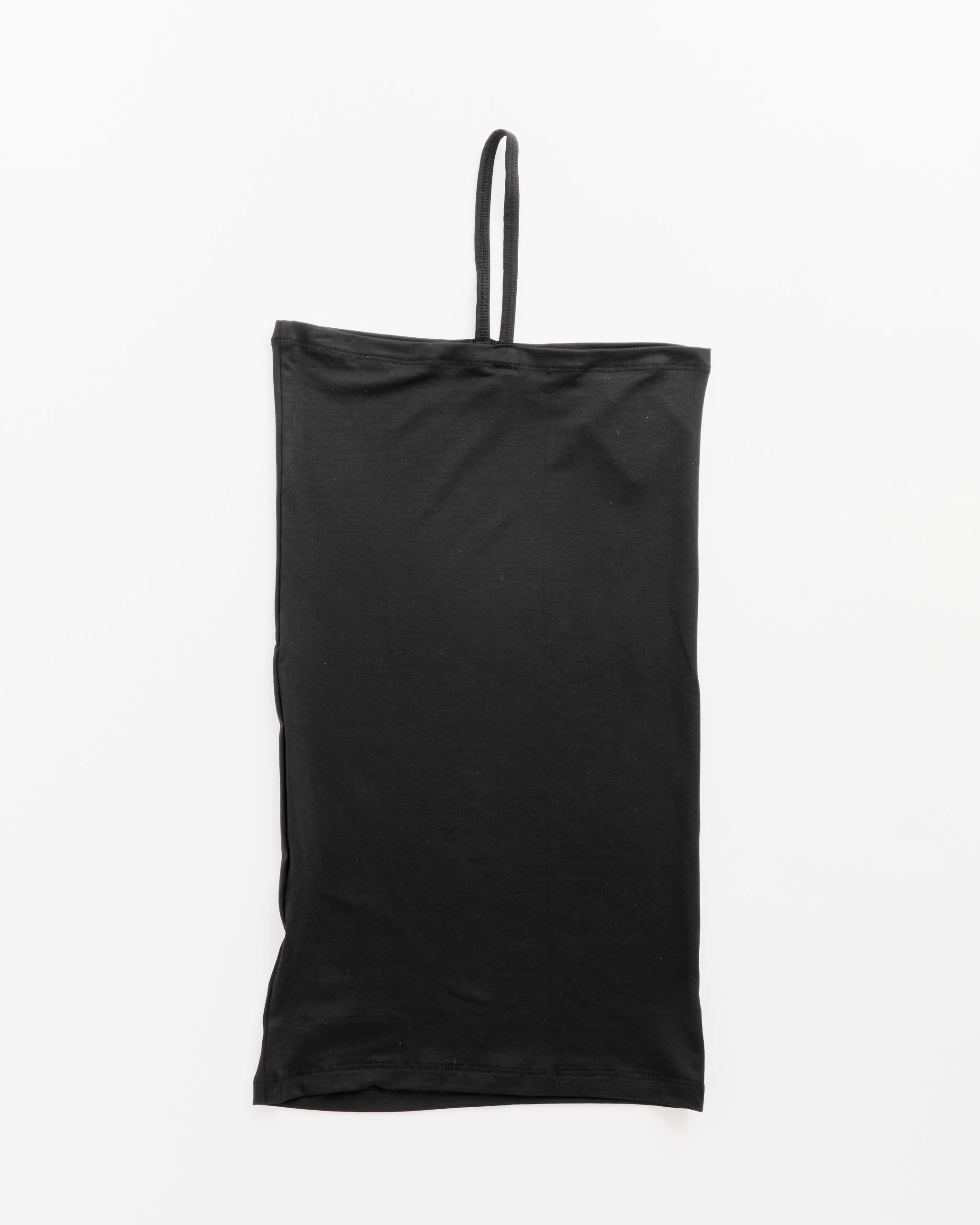 The Nida One Strap in Black by Baserange is a black tube top made from a soft blend of bamboo lyocell and elastane, featuring a single thin shoulder strap, shown laid flat on a white background.
