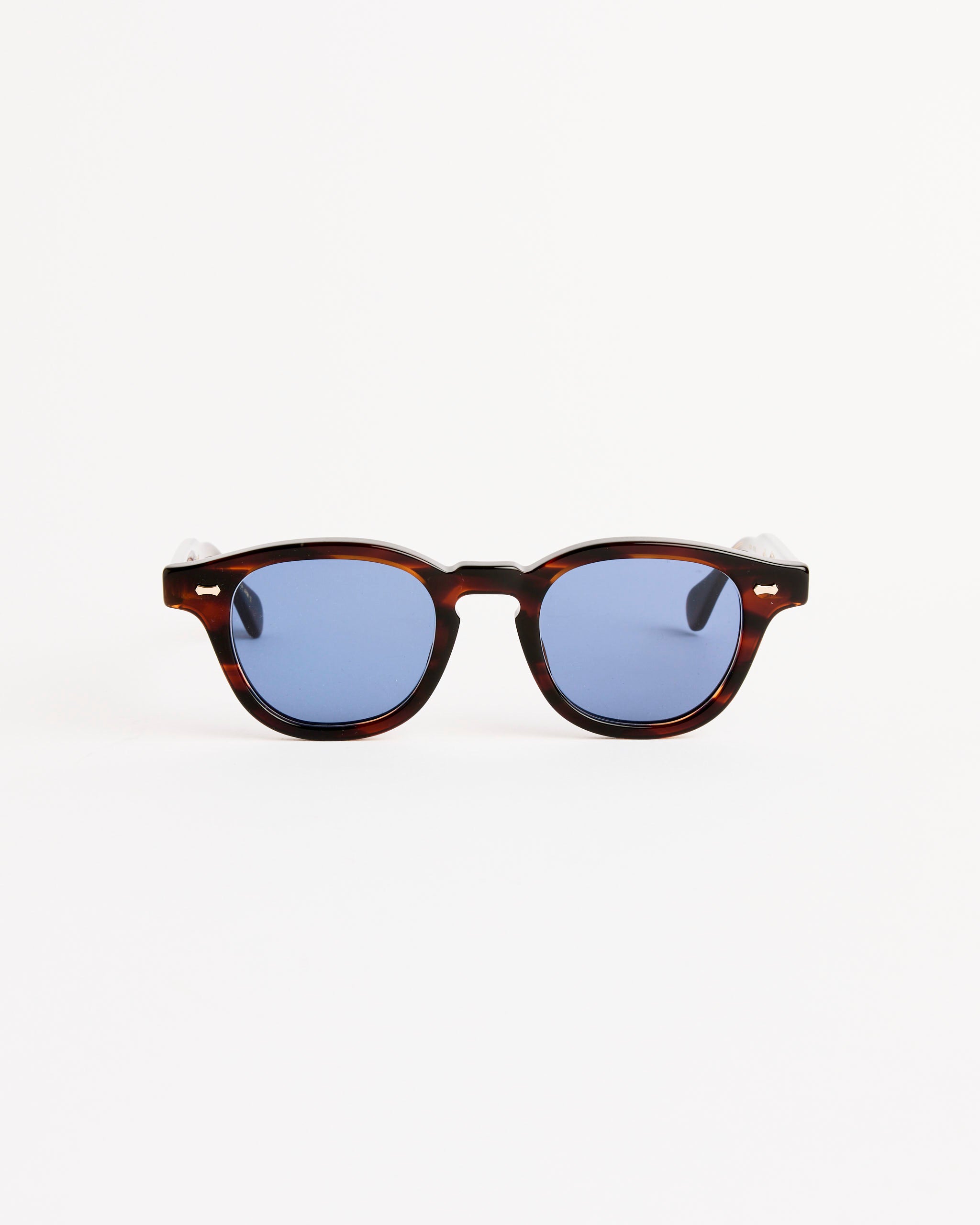 A pair of Shady Character Arnie Sunglasses in Root Beer Sasa/Mid Grey, featuring mid grey lenses and a glossy tortoiseshell frame, handcrafted in Japan with UV protection, displayed against a plain white background.