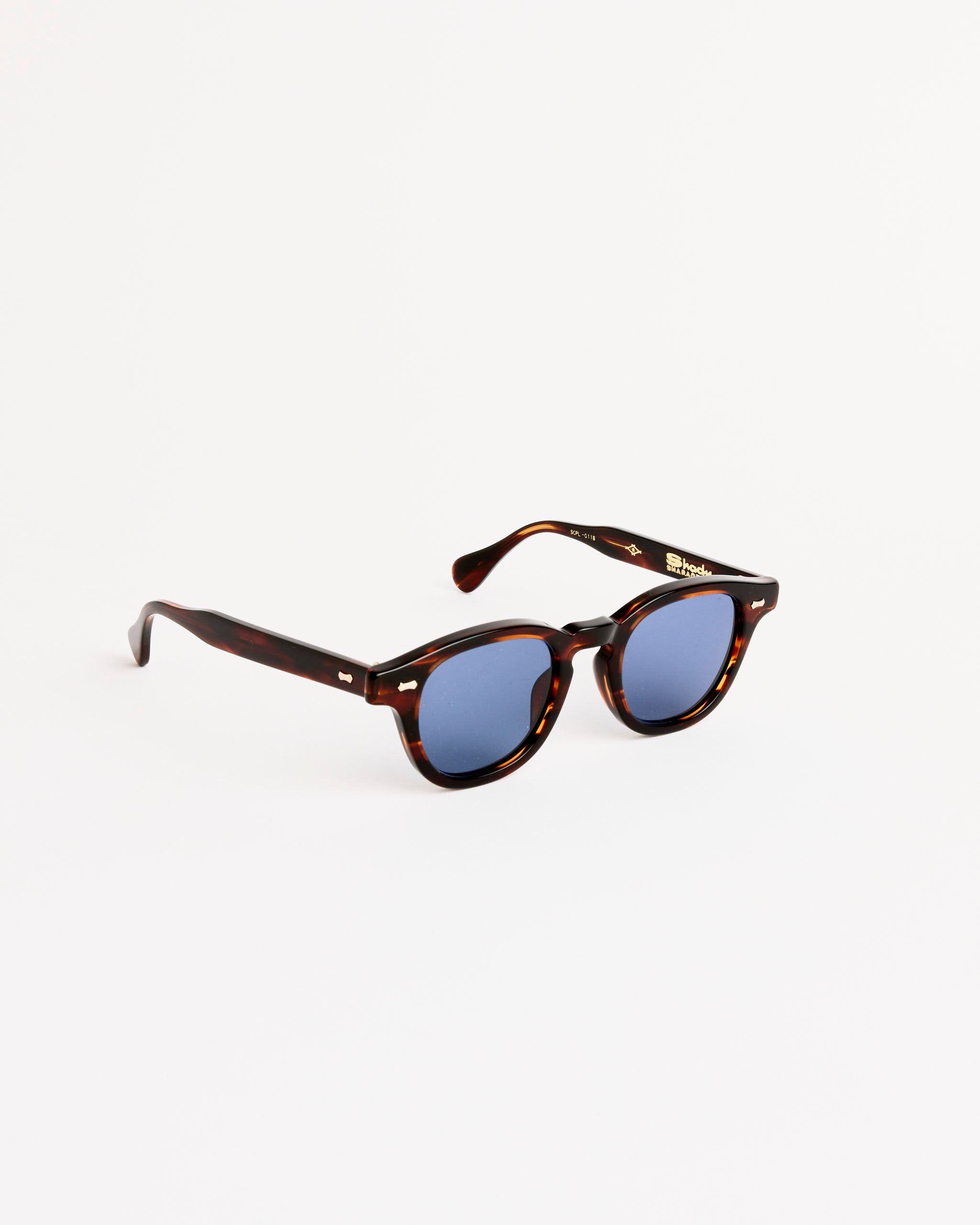 The Shady Character Arnie Sunglasses in Root Beer Sasa/Mid Grey offer handcrafted Japanese quality, premium UV protection, and round frames, all displayed on a plain white background for style and clarity.