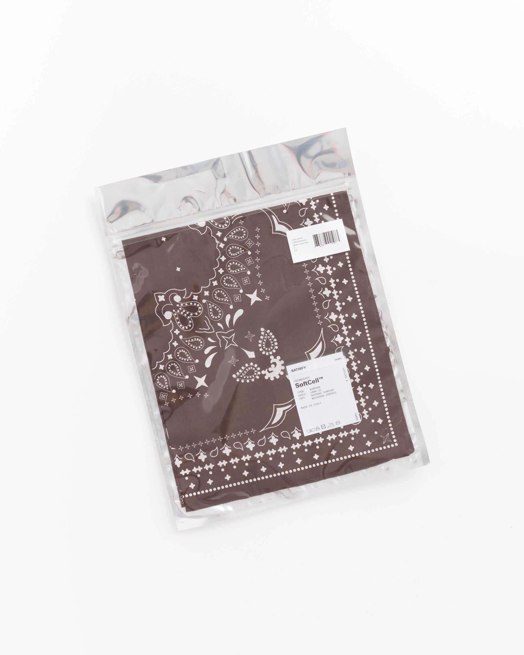 A Satisfy Running SoftCell Bandana in Walter Rocky Road is neatly folded inside a clear plastic resealable bag, placed on a white surface. A barcode and small label with text are visible on the packaging, highlighting this breathable bandana’s comfort and quality.
