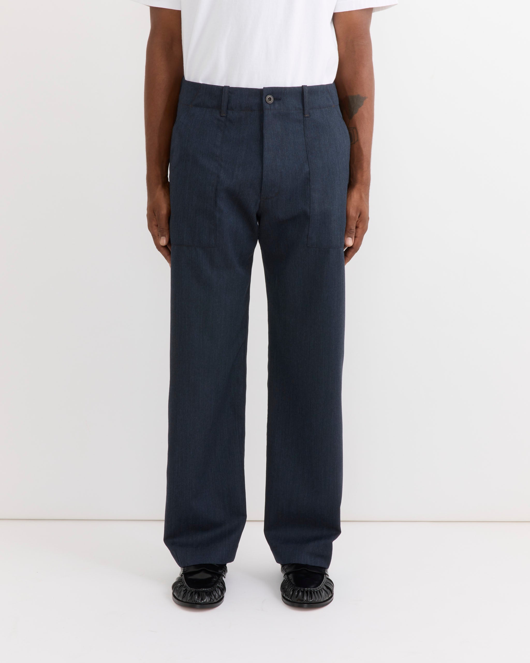 A person wearing a white shirt and the SMOCK Toyon Pant in Wool Gabardine Heather Navy stands facing forward against a plain white background, with only the lower half of the body visible.