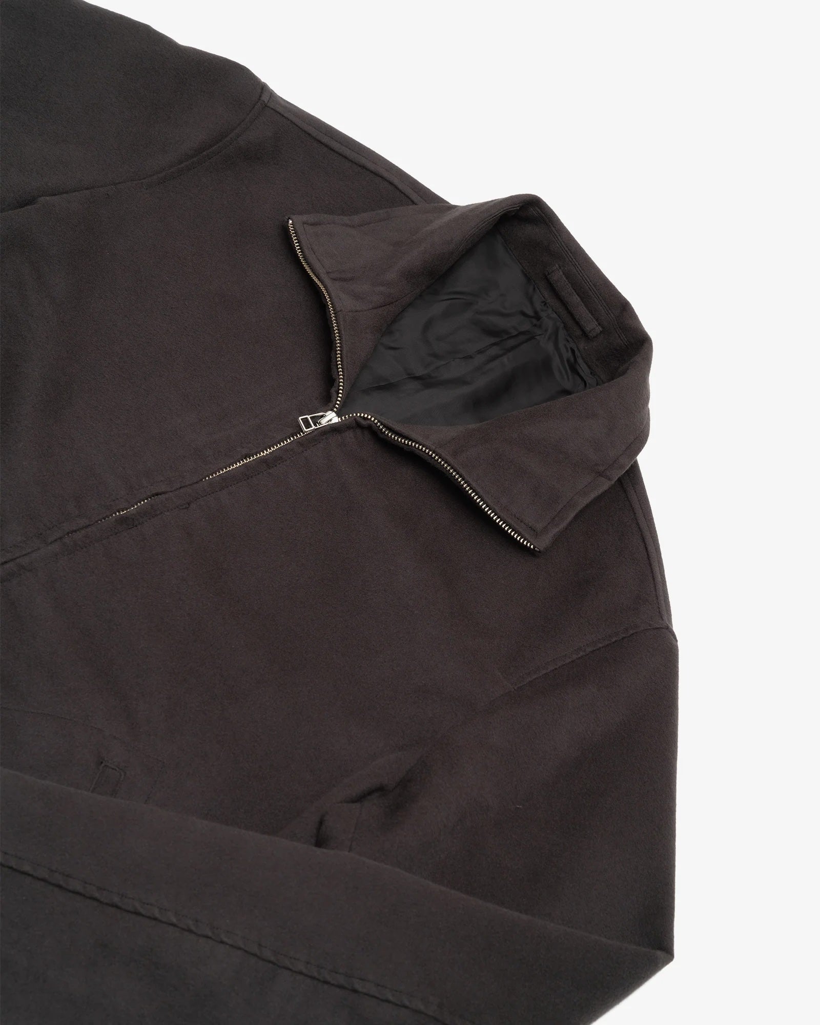 A close-up of the James Coward Circuit Jacket in Charcoal, featuring a collar and partially unzipped metal zipper, crafted from Japanese cotton moleskin. This heavyweight piece is made in Vancouver and laid flat on a white background.